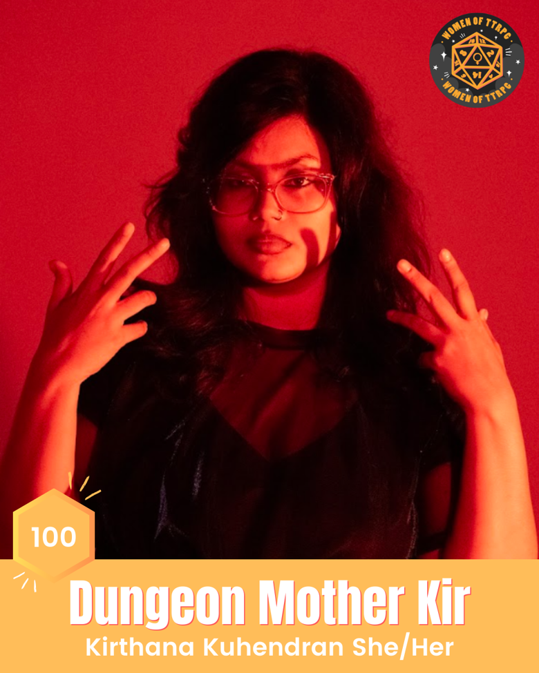 Kirthana Kuhendran (she/her) has black hair, is wearing a black tshirt, glasses, and is standing in front of a dramatic red background.