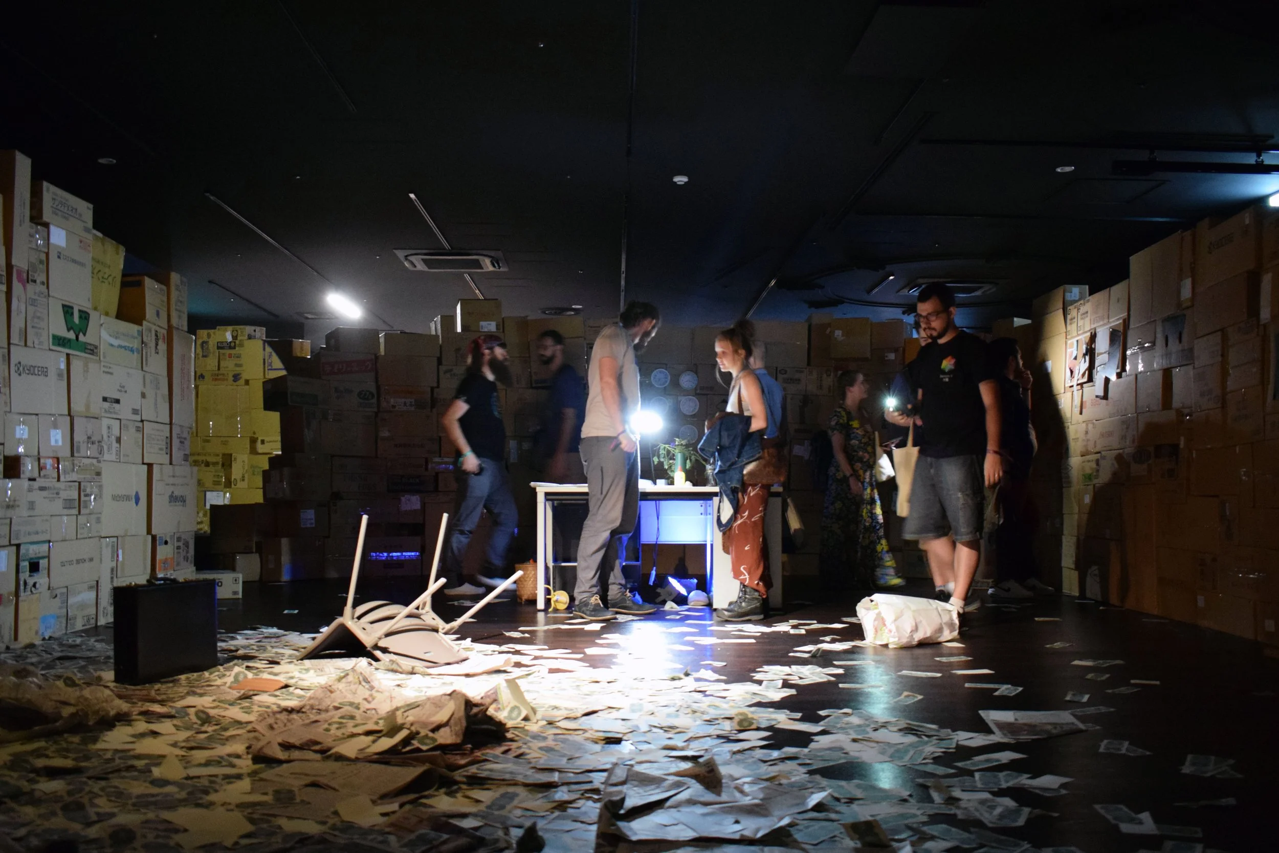 Visitors exploring the immersive ‘Present’ environment, searching through papers, boxes and objects for hidden fragments of NFT artworks and Kong notes.