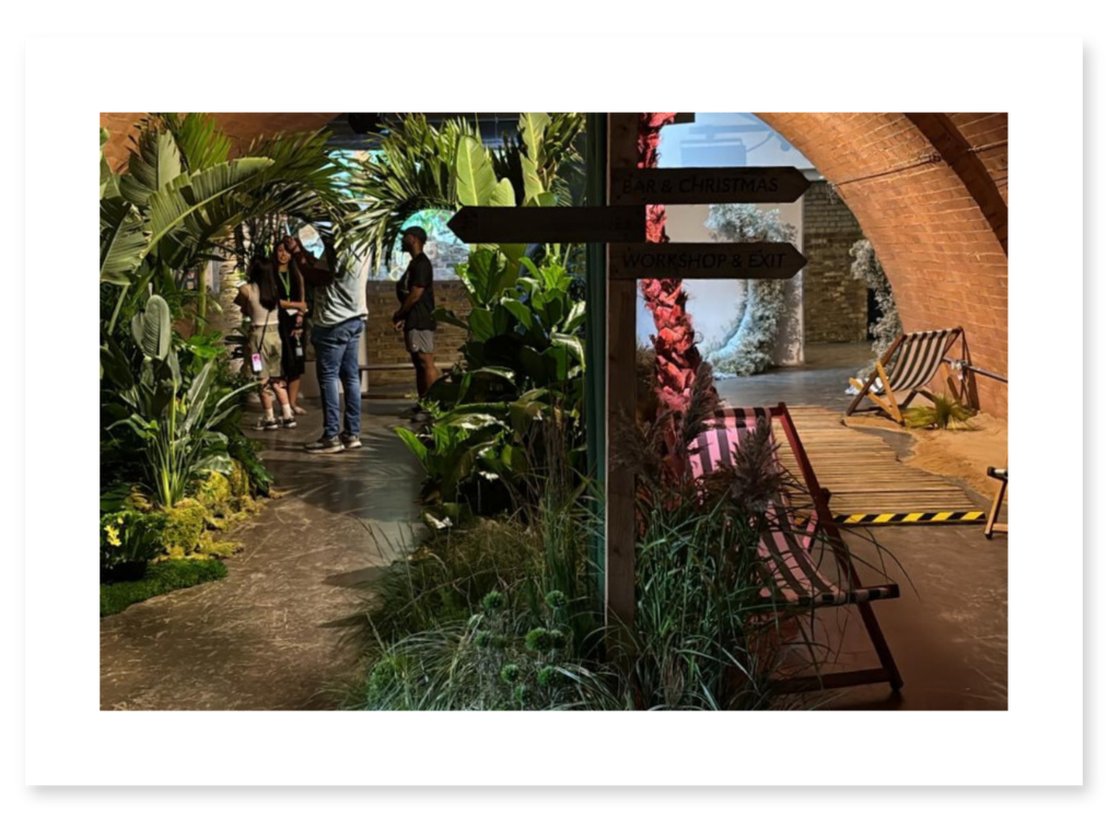 Immersive event design combining lush planting with a playful beach-inspired installation.