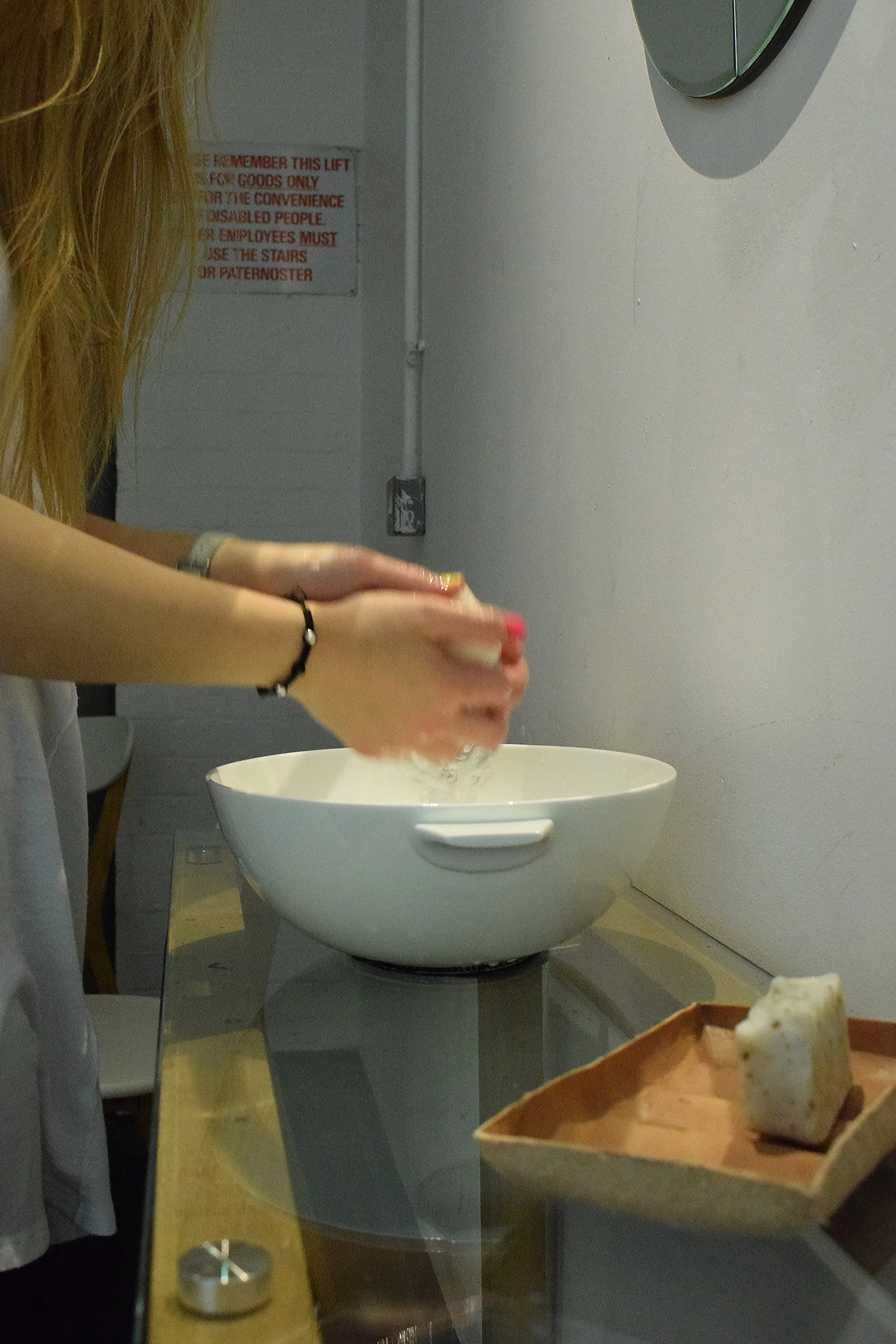 Participant washing their hands with tallow soap in a bone china bowl as part of the guided multi-sensory experience.