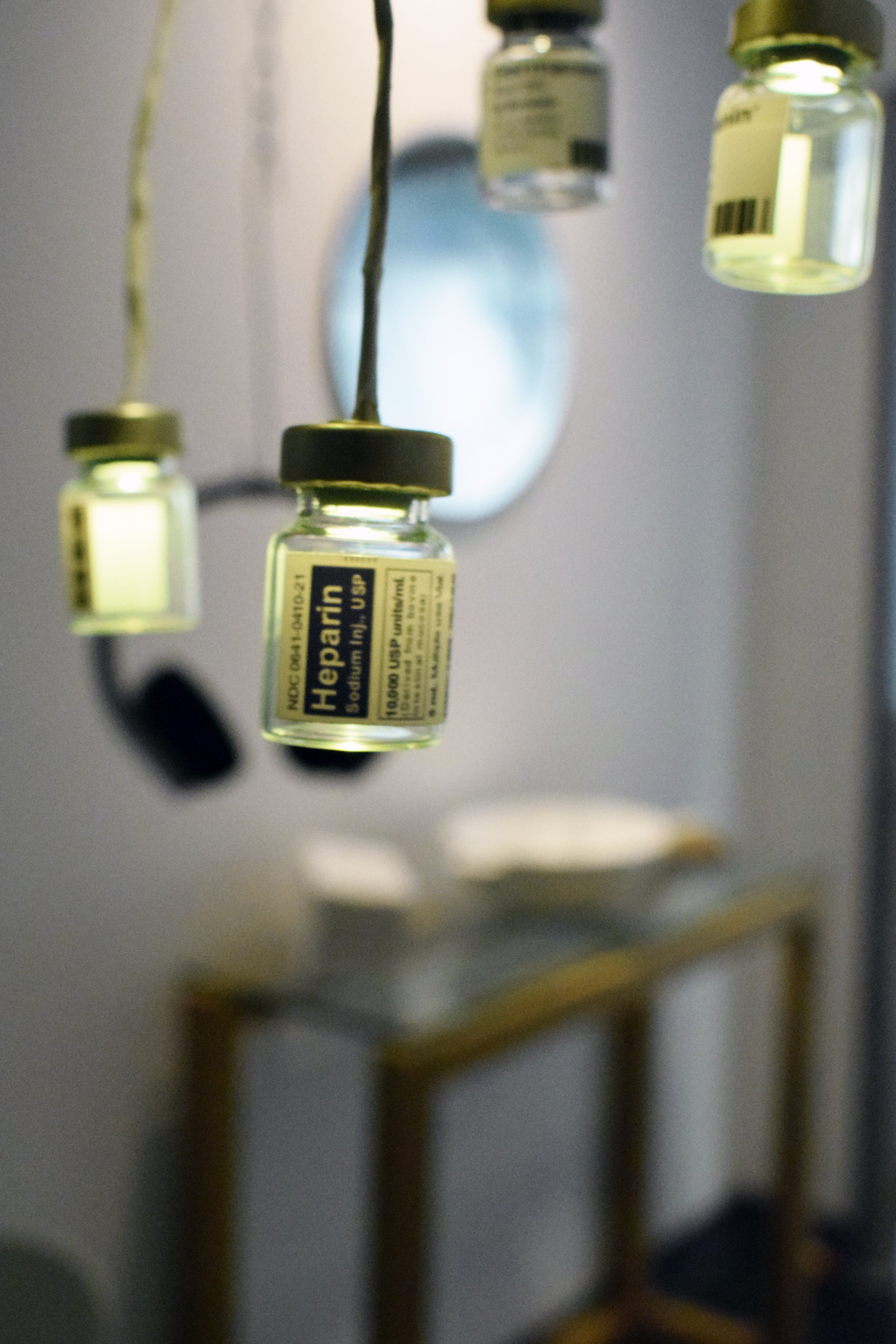 Replica vials of bovine-based medicine suspended as part of the immersive installation.