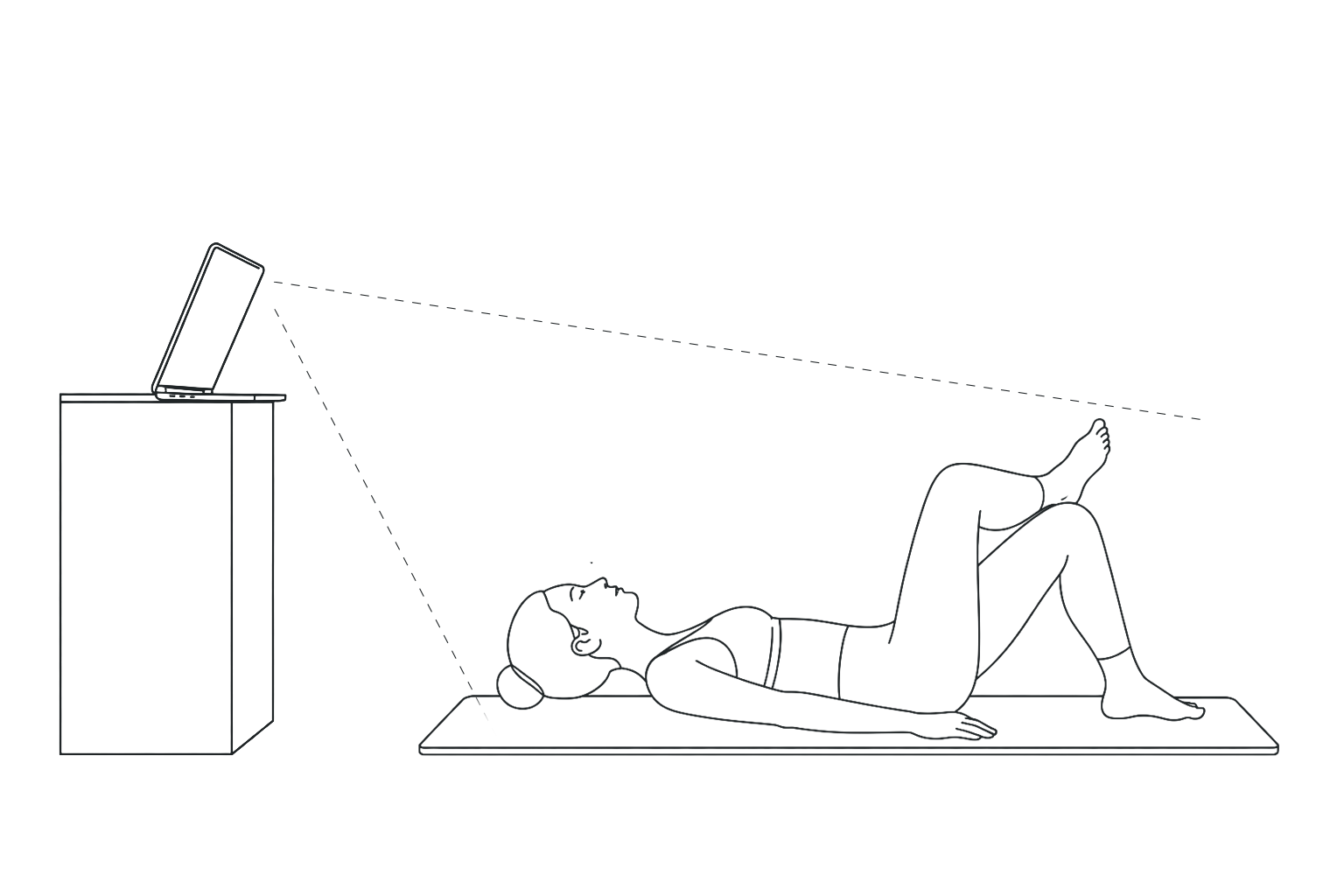 Personne allongée sur un tapis de yoga effectuant un exercice de breathing, regardant le plafond, avec un ordinateur placé sur un meuble devant elle