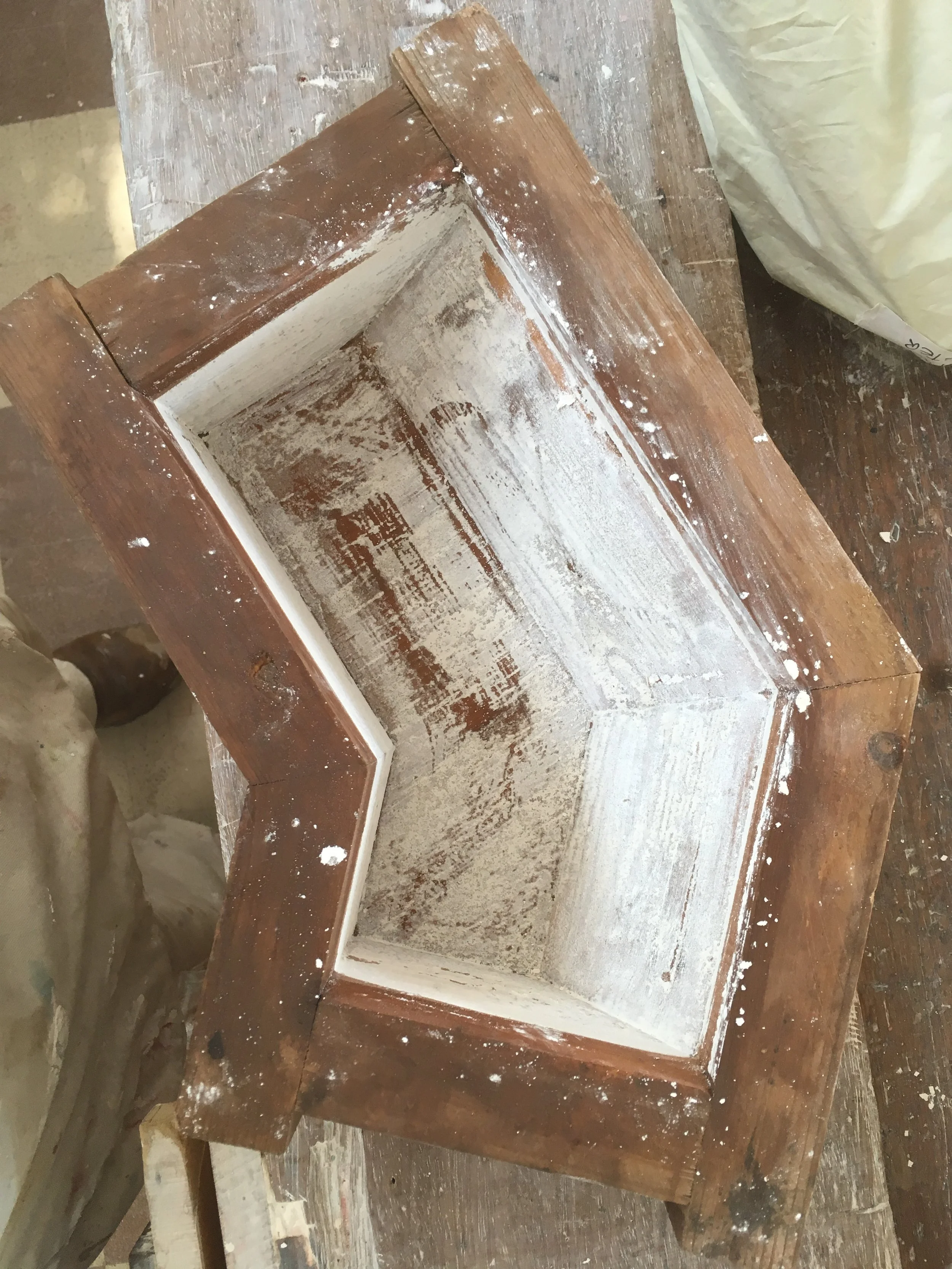 An olde wooden brick mould for a brick with a bend in the middle