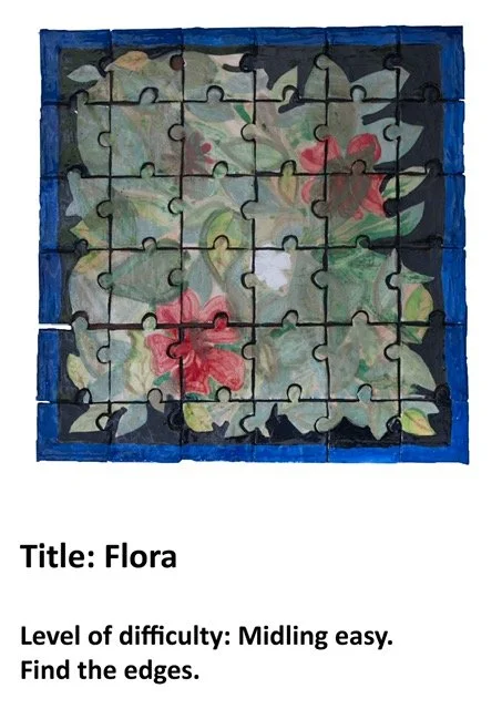 A completed 3x3 jigsaw puzzle with a floral design featuring hibiscus flowers and green leaves, framed with a blue border.