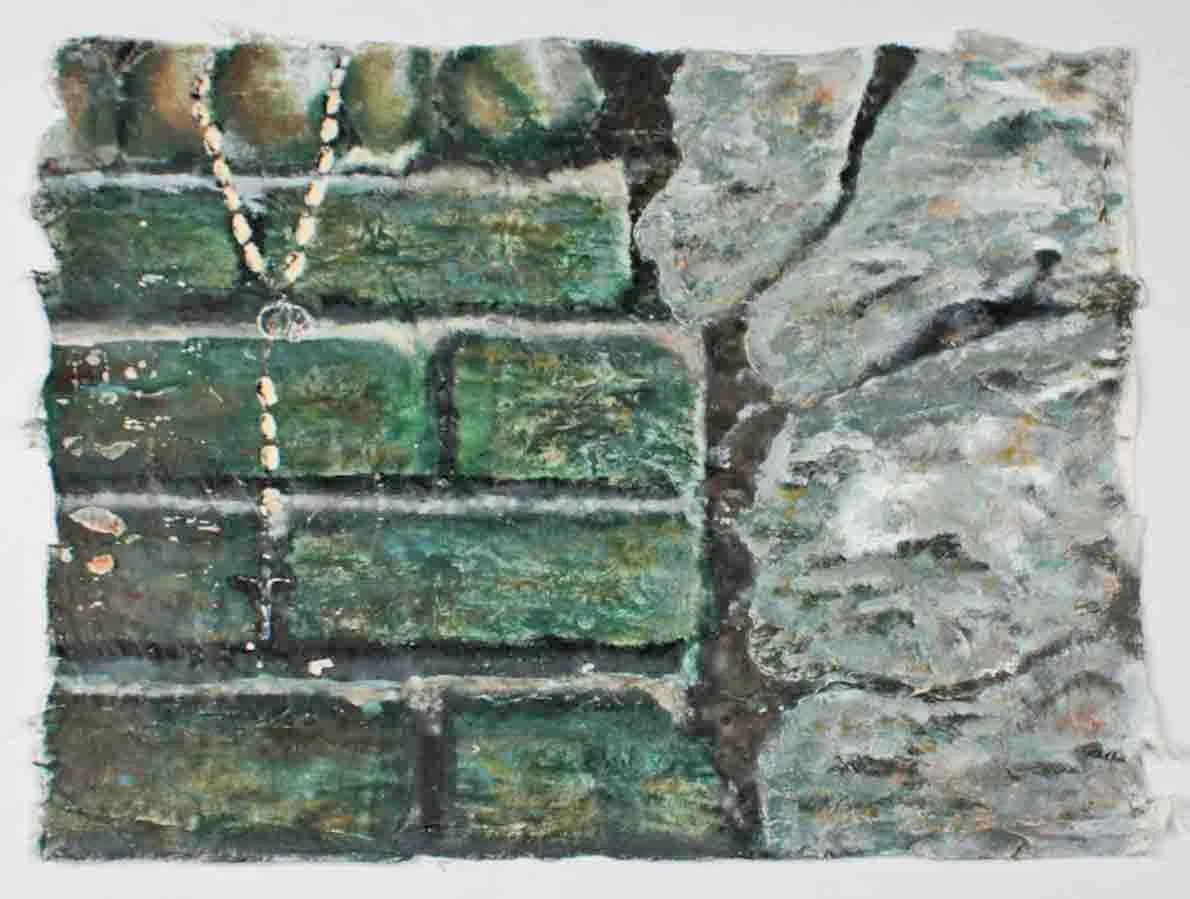 Painting of a weathered brick wall with green paint and a string of small beads hanging down.