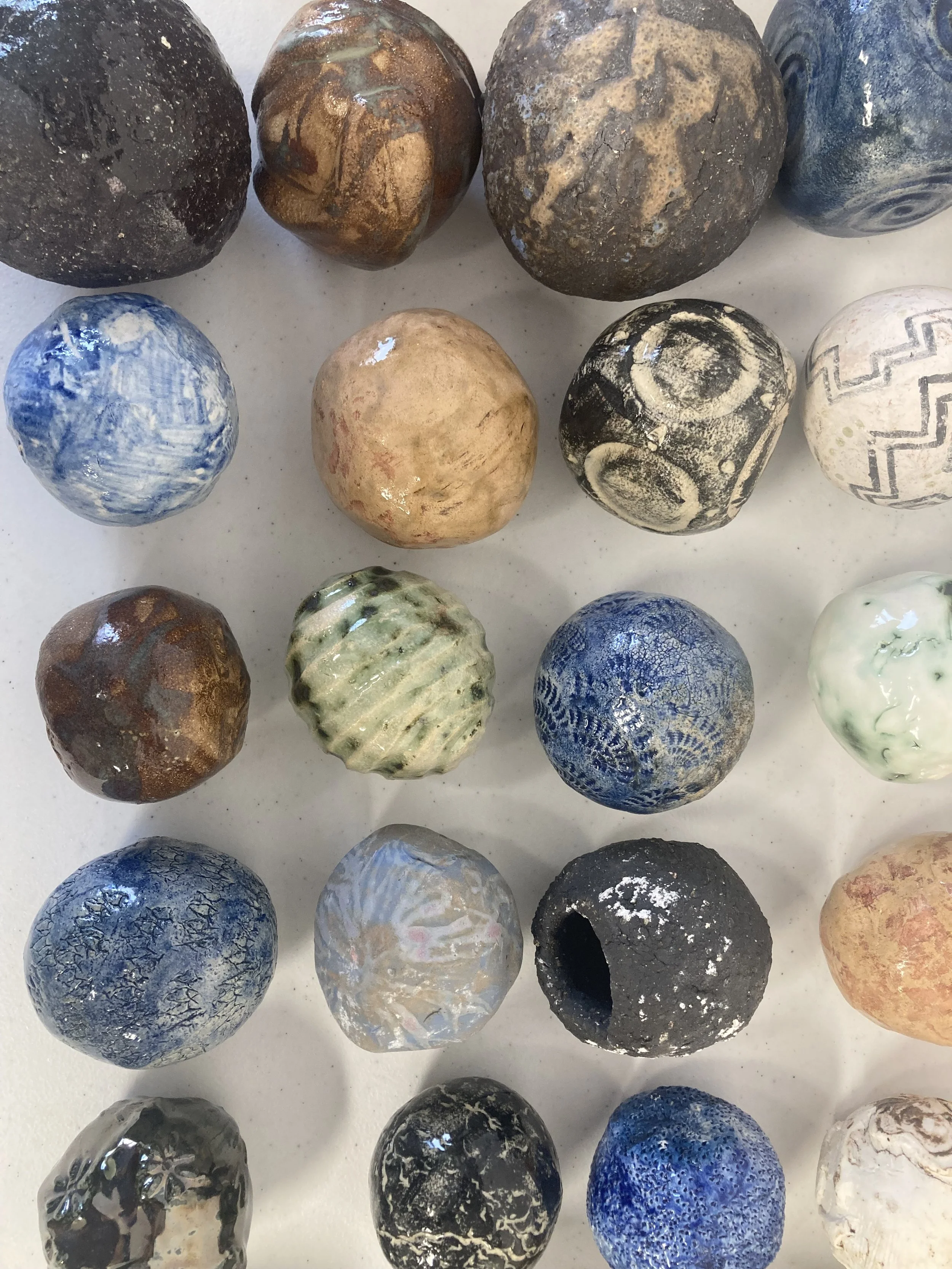 A collection of polished decorative stones in various colors and patterns, arranged on a flat surface.
