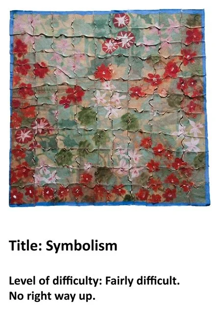 A puzzle with a floral pattern featuring red and pink flowers, green leaves, and a blue border.