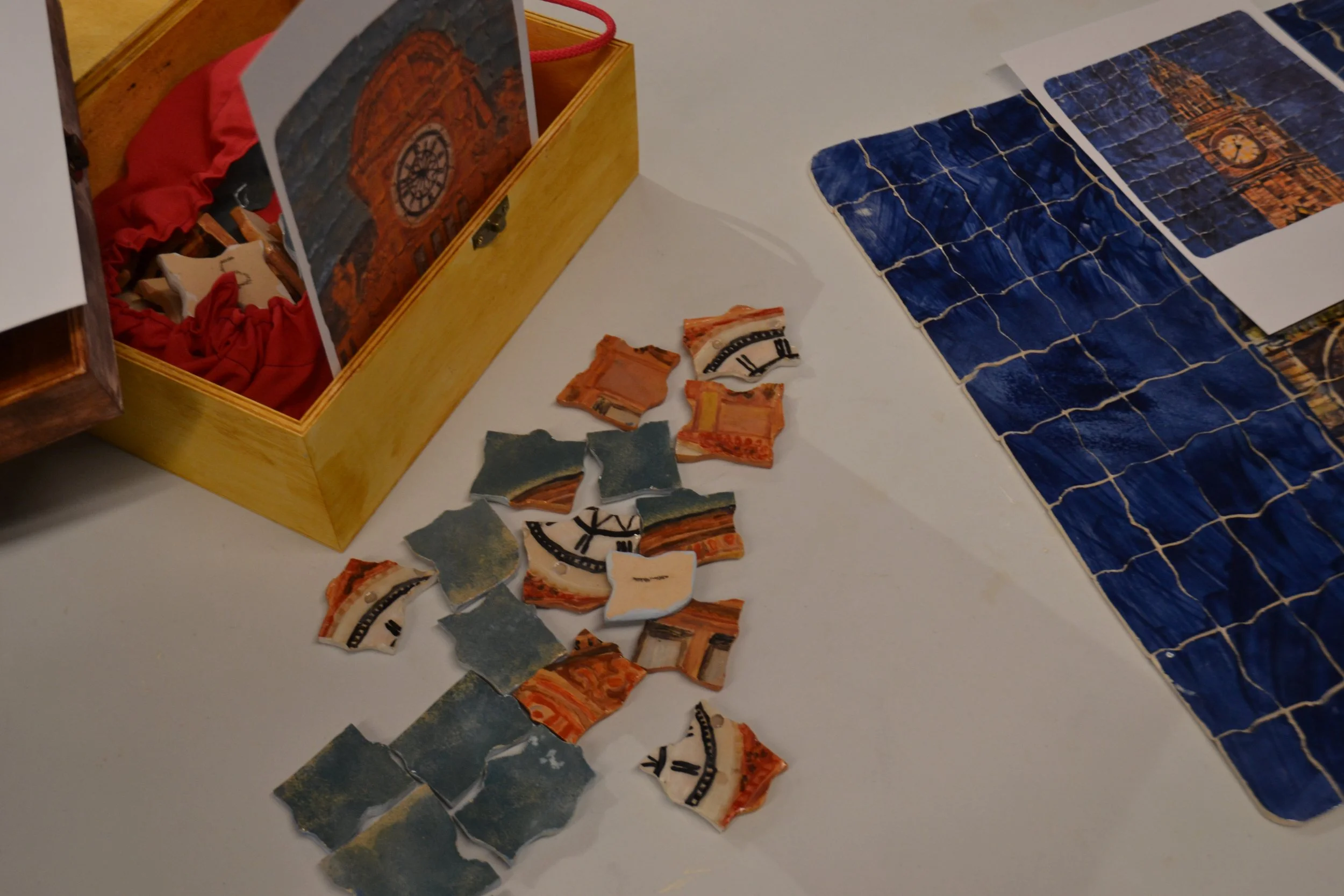 Colorful puzzle pieces and a puzzle box with an illustration of Big Ben in London, England, on a table.