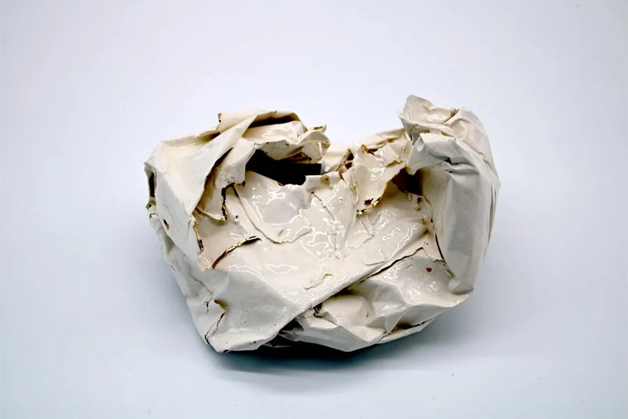 white ceramic piece that looks like scrunched paper with gold on some edges