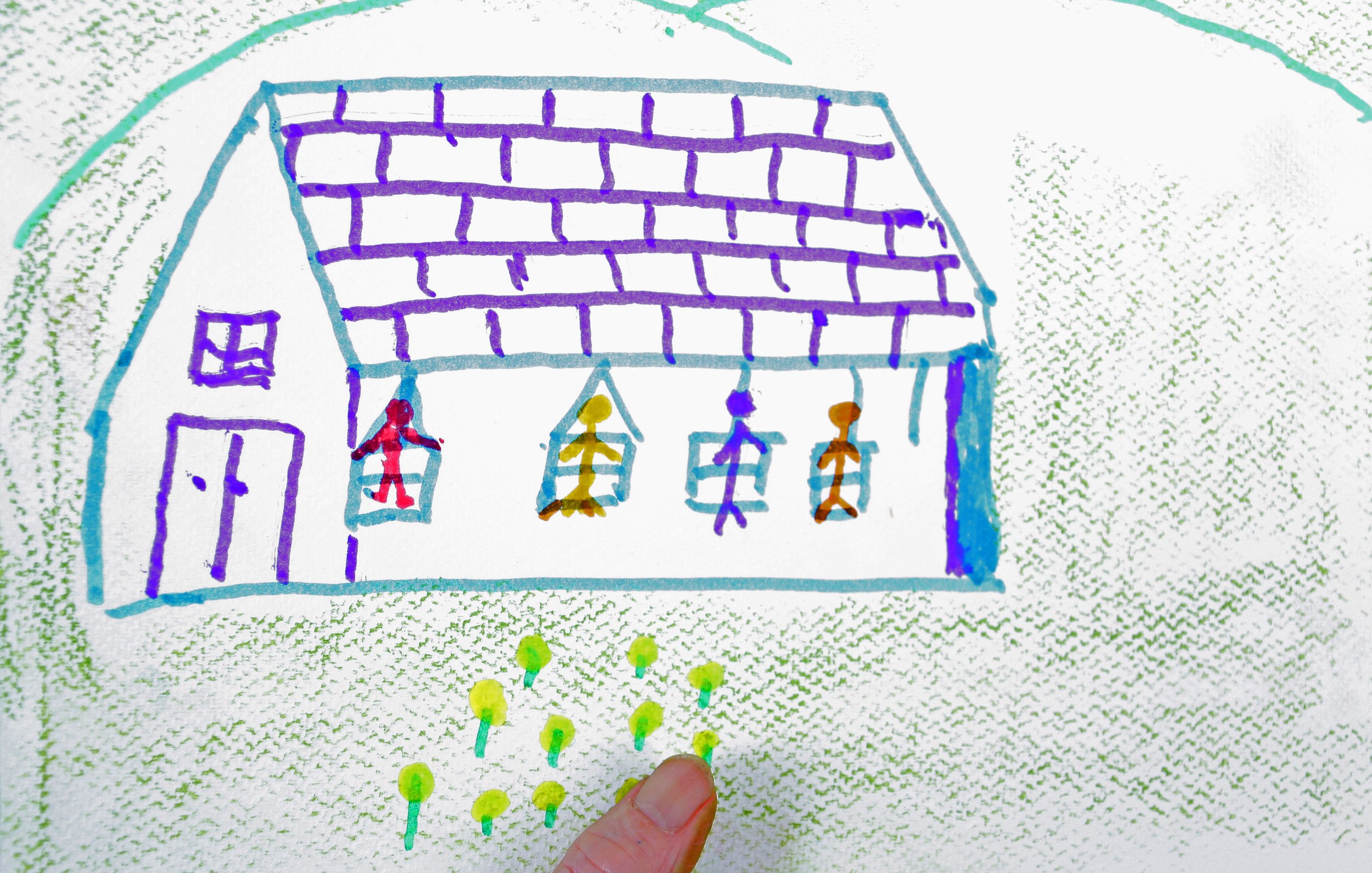 Child's drawing of a house with three floors, a purple roof, purple walls, a single window, and a red door. The house has three hanging swings with children colored in red, yellow, purple, and orange. Surrounding the house are green dots and lines representing grass and pathways, and a hand is holding the drawing.