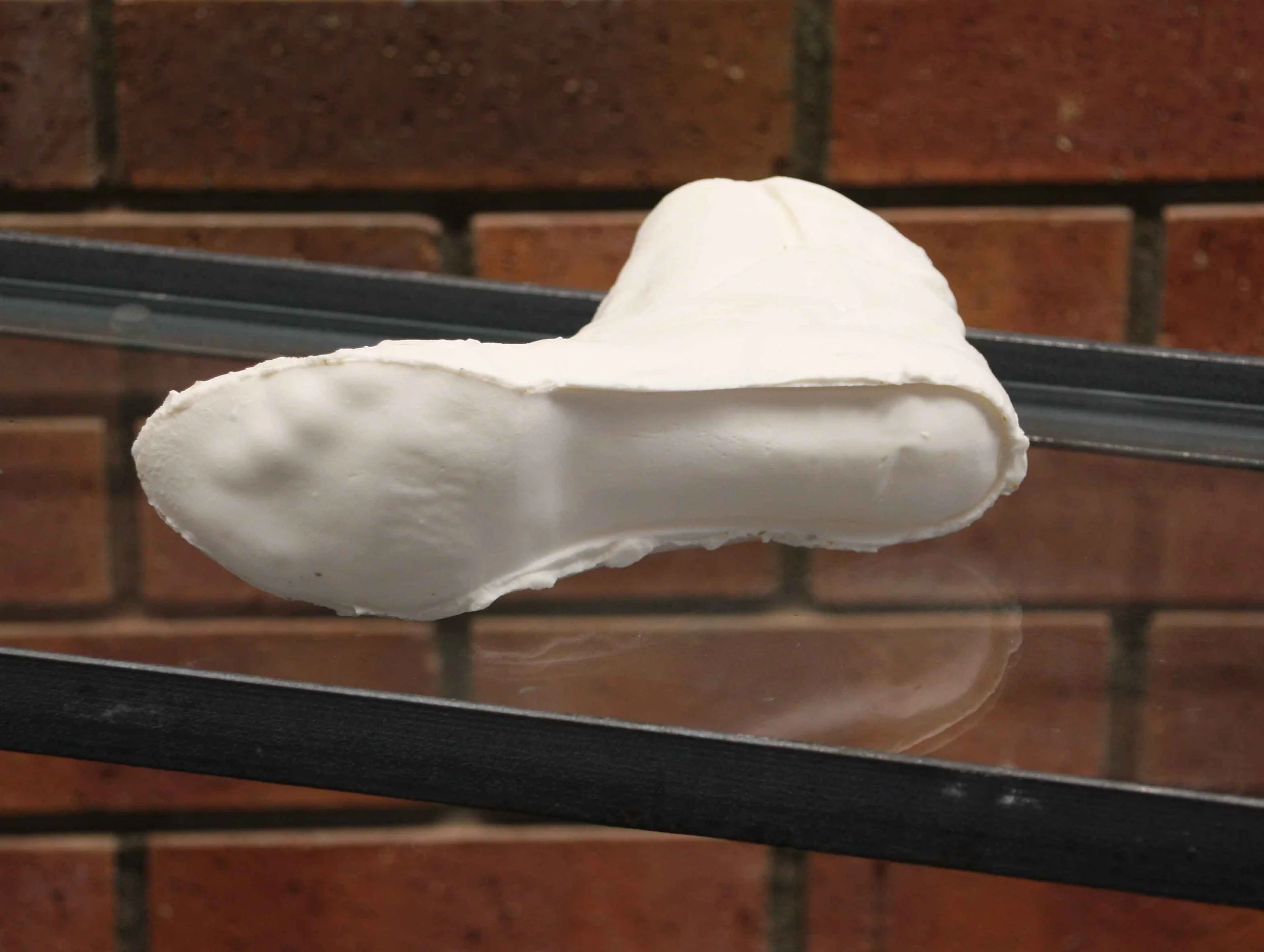 close up of a cast foot, with a brick wall in the background.