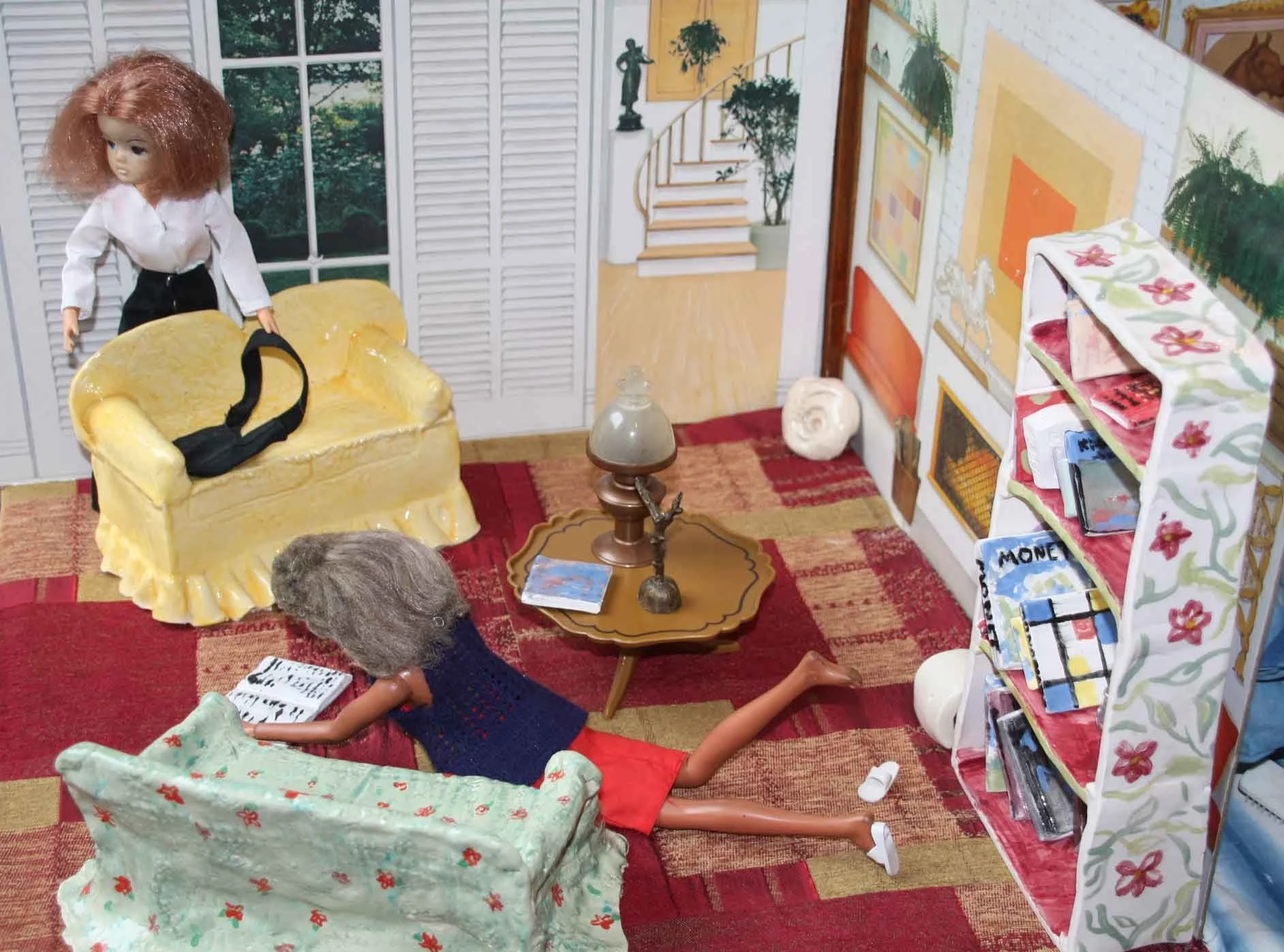 Four dolls in a living room scene with a red carpet, a coffee table, a bookshelf, and wall art. One doll is seated on an armchair, another on the floor reading a book, and two others are standing or seated around the coffee table.
