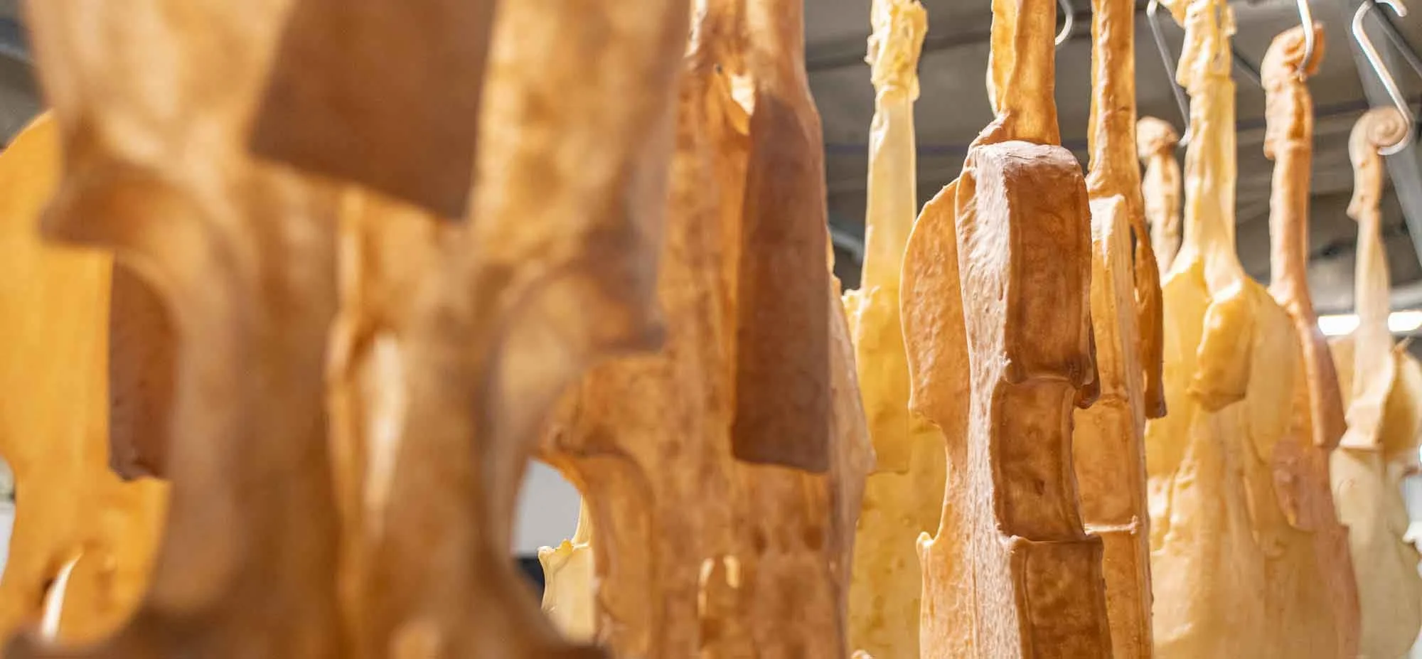 Lots of latex violin skins hanging from hooks like cured meat