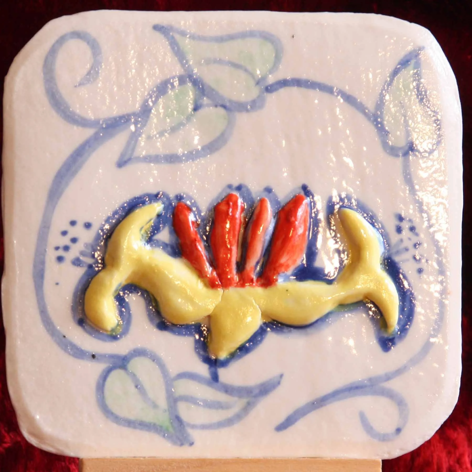 Decorated soap with a floral design in blue, yellow, and red colors on a white background.