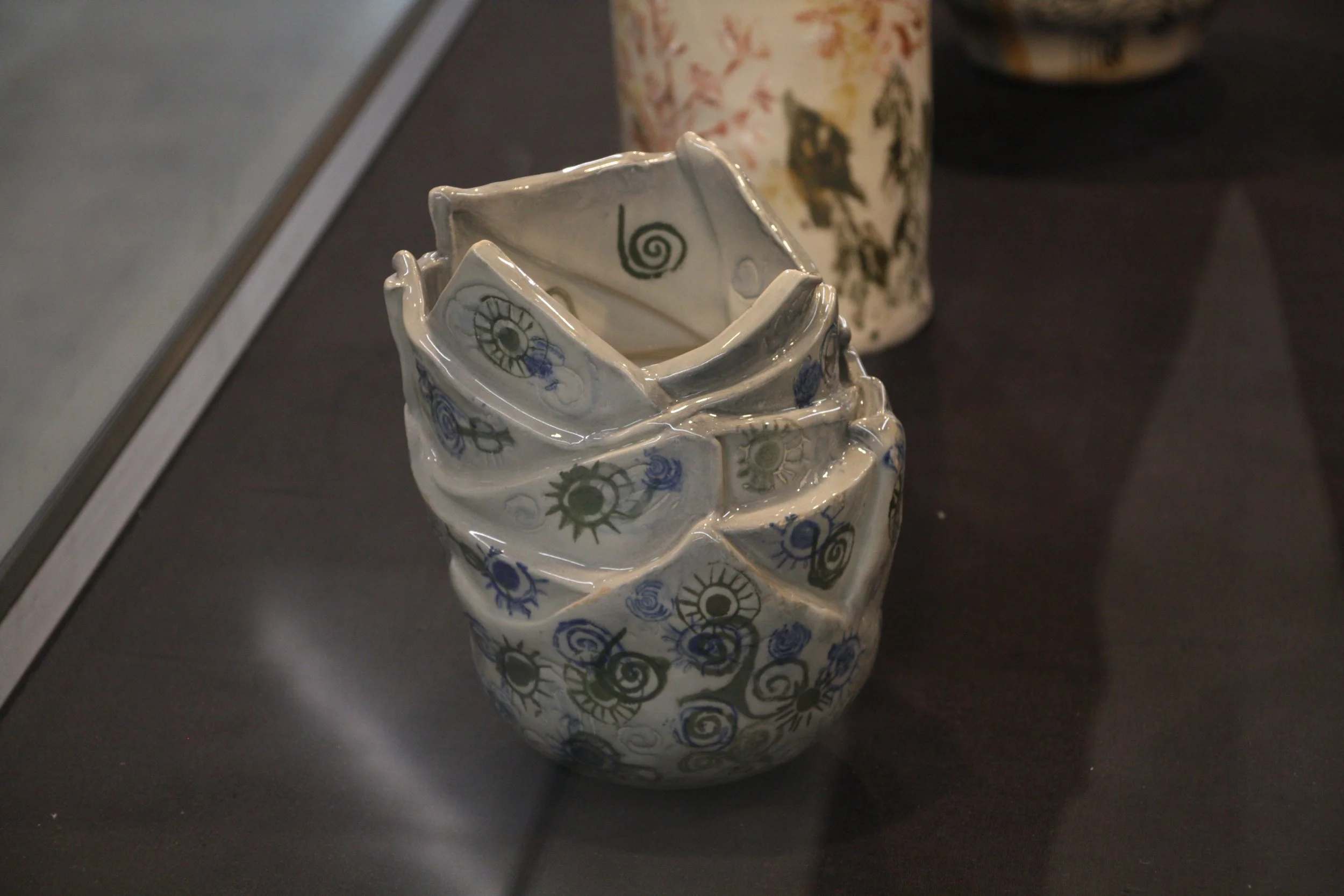 Stacked ceramic bowls with blue and black swirl and eye designs.
