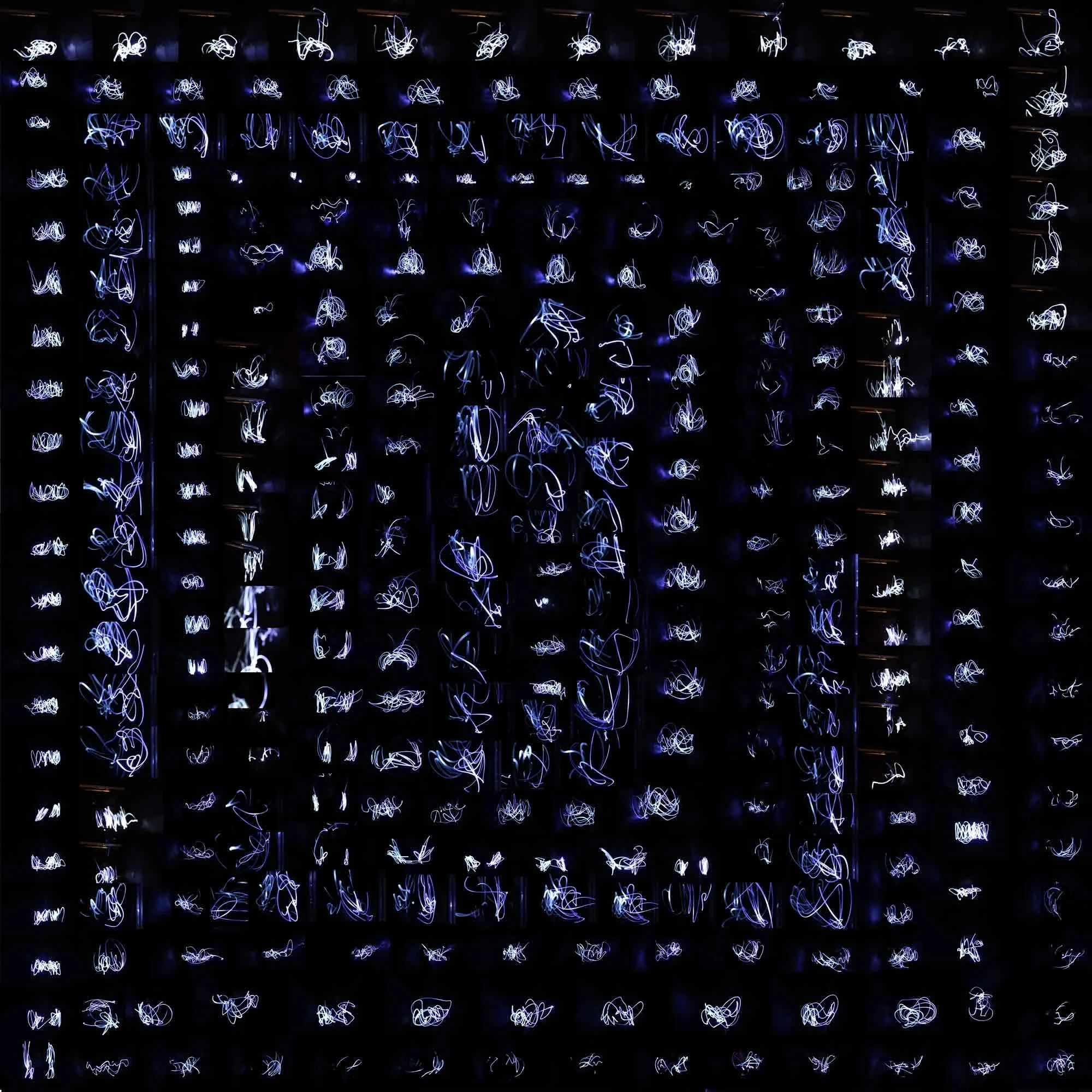 Light painting with white and blue light trails on a dark background, creating abstract swirling patterns.