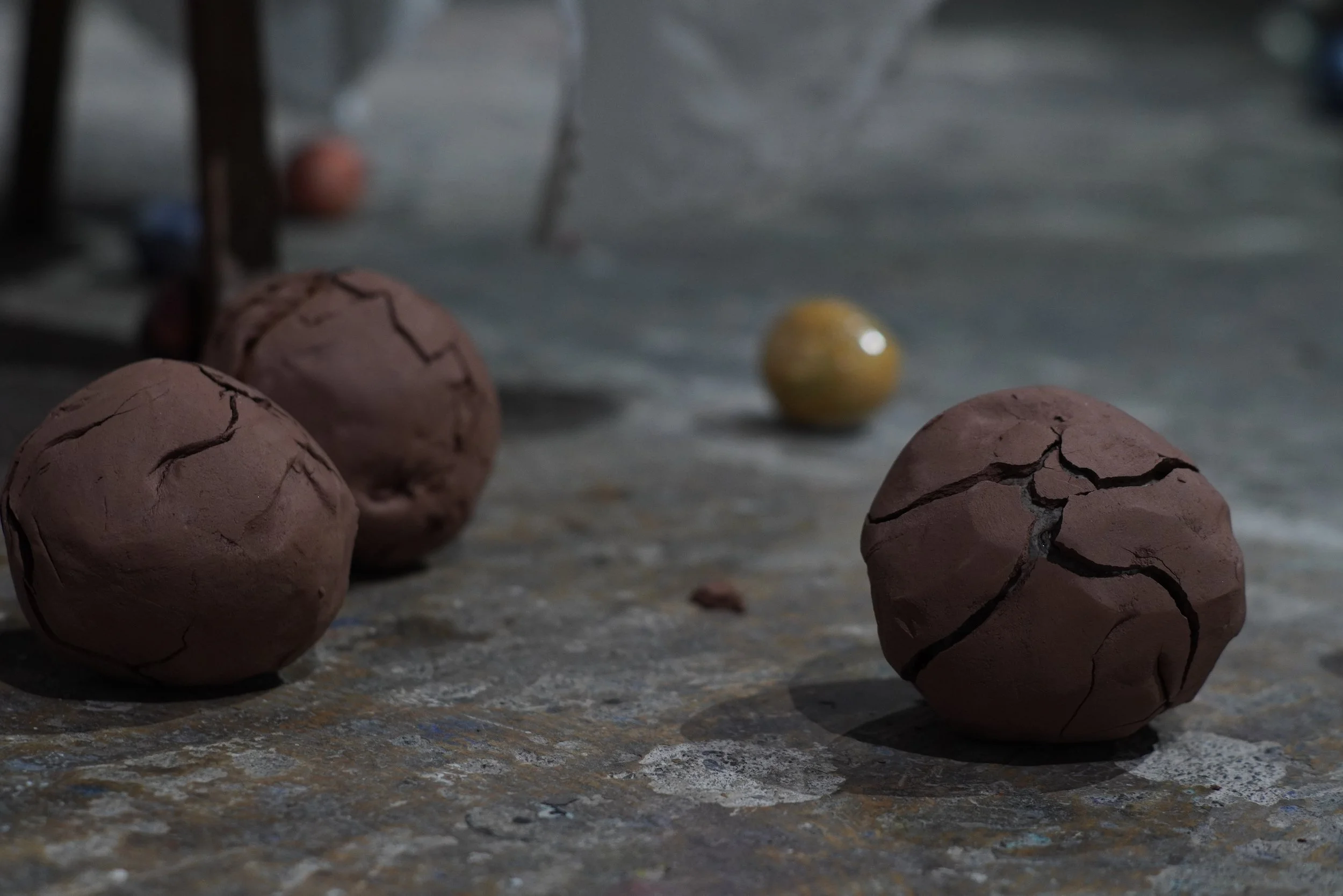 Close-up of several cracked, brown eggs on a rough, textured surface with a yellow yolk in the background.