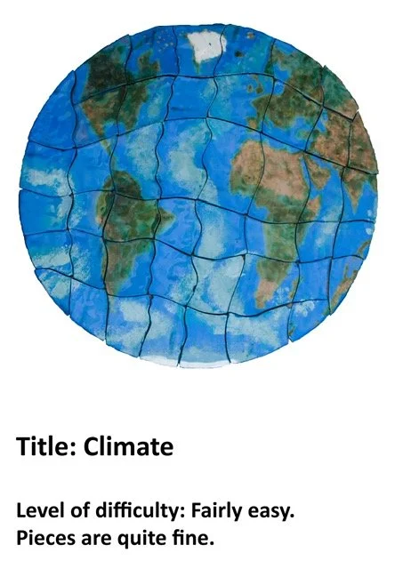 A jigsaw puzzle of a world map showing the continents and oceans in green, brown, and blue colors. The puzzle is assembled on a white background.