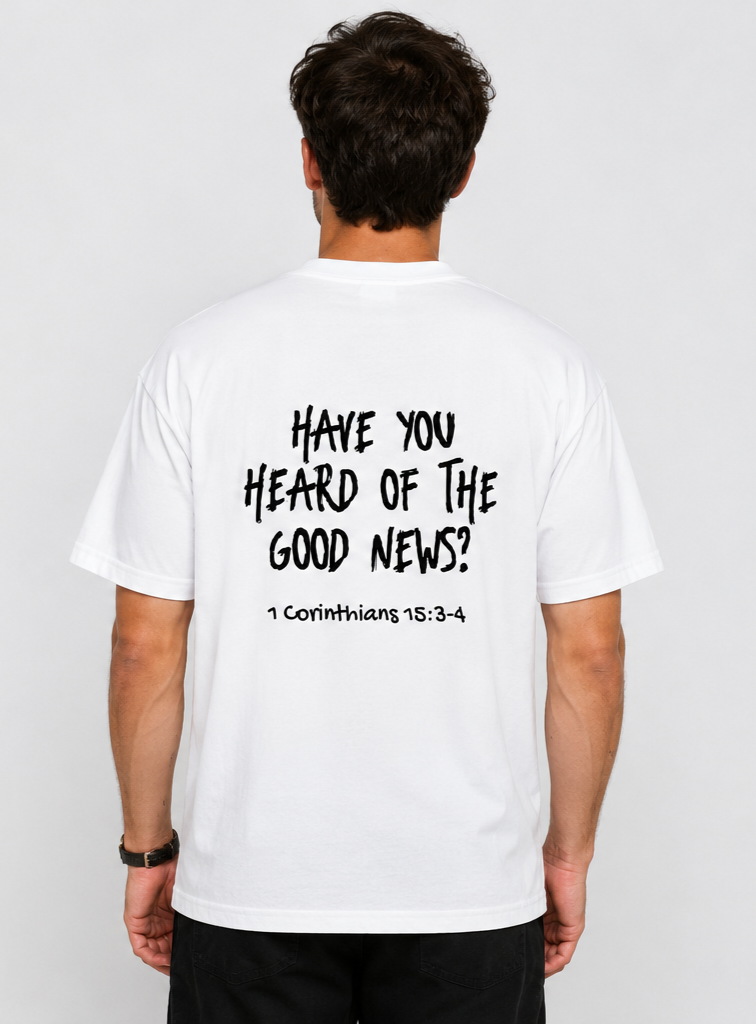 Back view of a man wearing a white T-shirt with black text that reads 'Have you heard of the good news? 1 Corinthians 15:3-4' against a plain gray background.