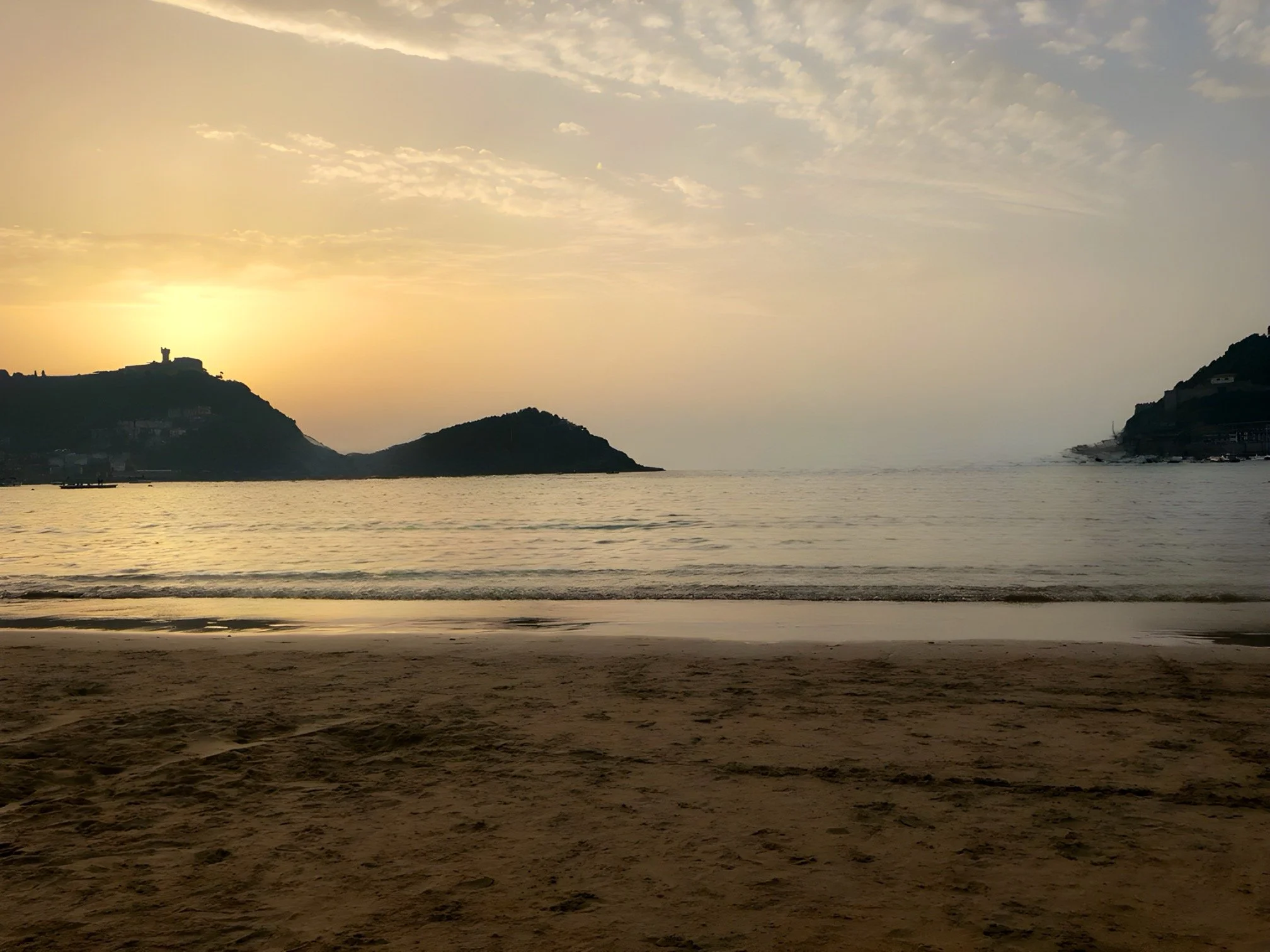 A sunset sky overlooking the ocean from the beach in San Sebastián, Spain.