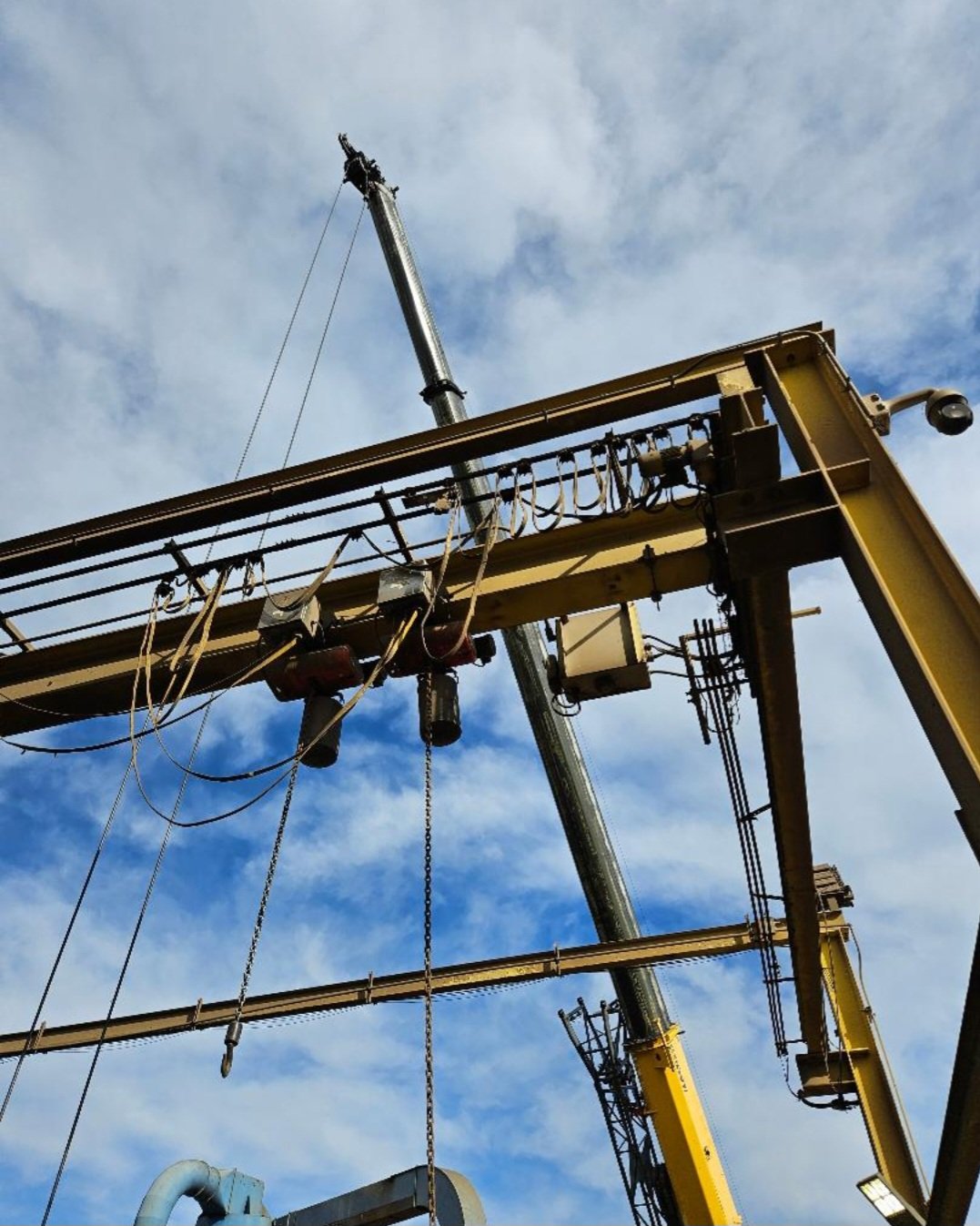 Construction cranes and equipment against a cloudy sky.
