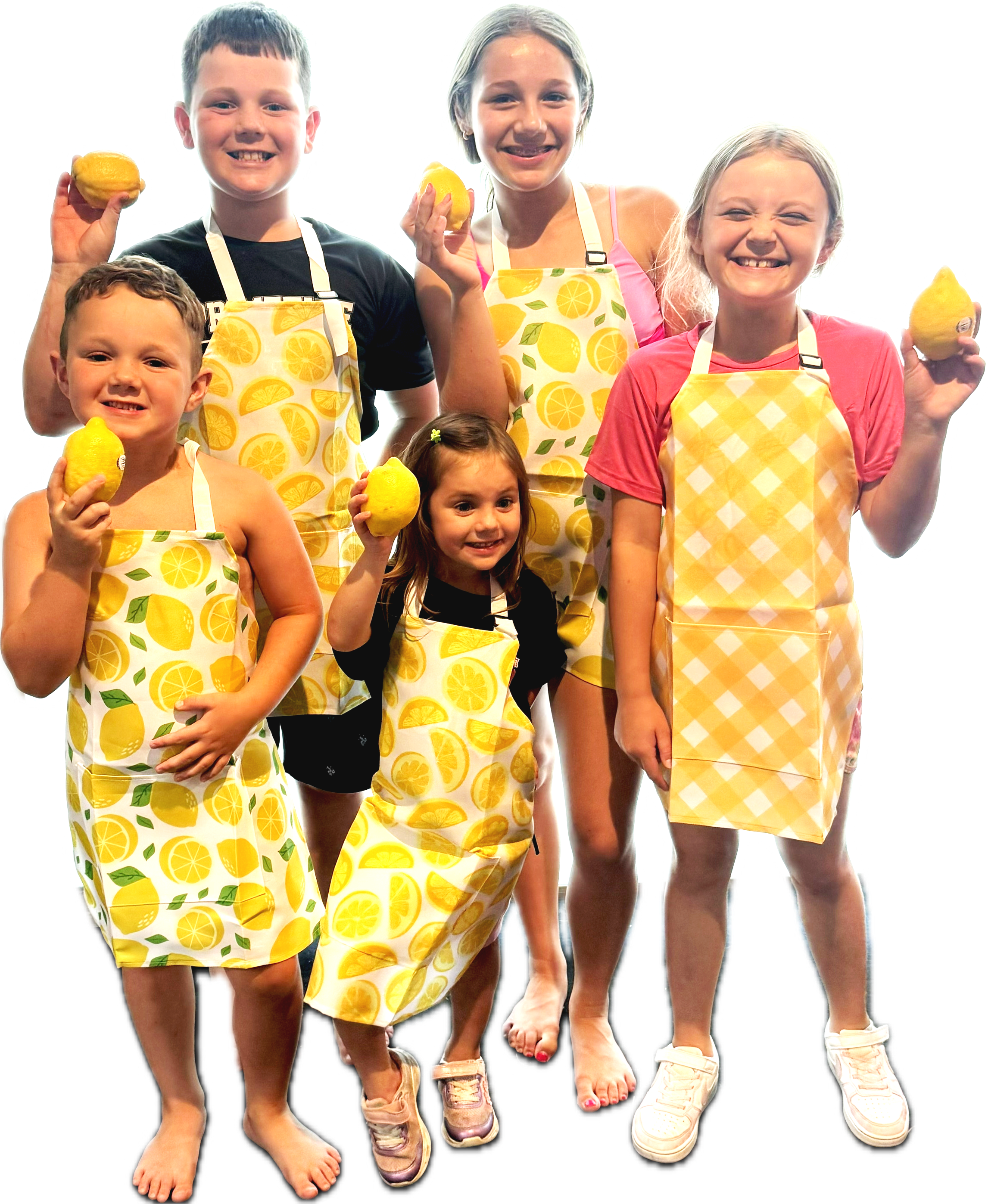 Five kids standing together, smiling, holding lemons, wearing aprons with lemon patterns, barefoot or wearing sneakers, in a cheerful setting.