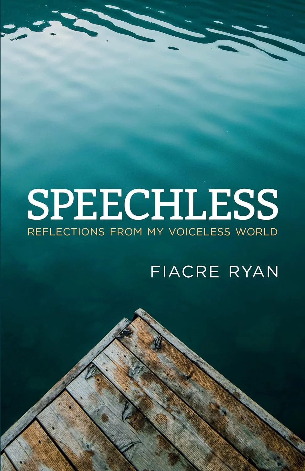 A wooden dock extends into calm, blue-green water with gentle ripples, accompanied by a book titled 'Speechless: Reflections from My Voiceless World' by Fiacre Ryan.