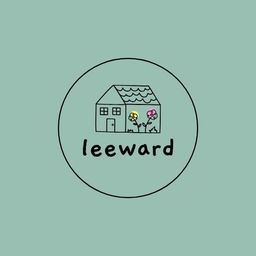 Simple illustration of a house with two flowers in front and the word 'leeward' beneath. The house has a door, windows, and a shingled roof, enclosed in a circle on a light green background.
