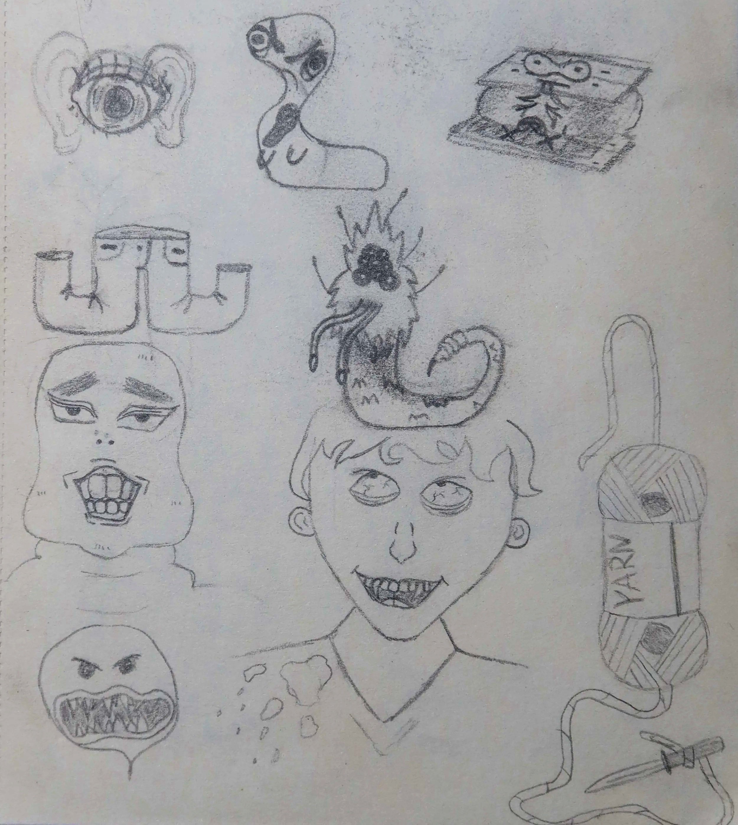 Hand-drawn sketches of various facial expressions and characters, including a cat, abstract faces, a snake, and other random doodles on paper.