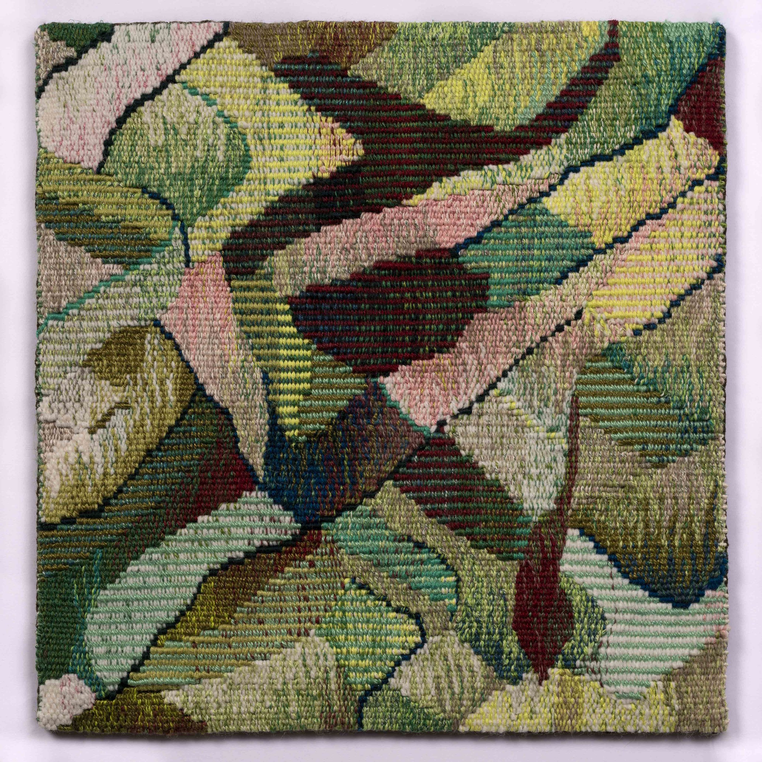 A woven textile artwork featuring colorful floral and leaf patterns in shades of pink, green, yellow, red, blue, and beige.