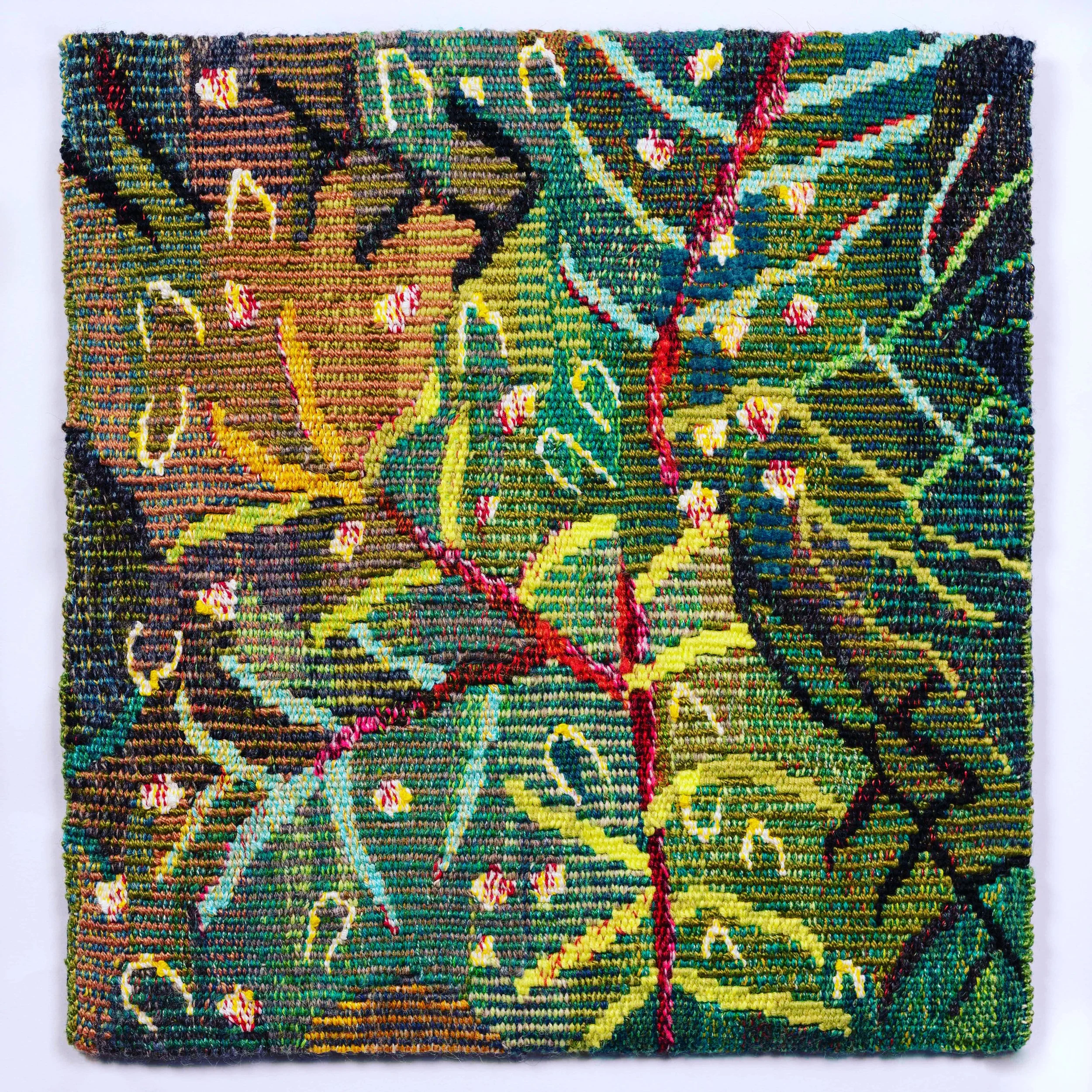 Close-up of colorful textured handwoven tapestry textile with floral and abstract patterns.