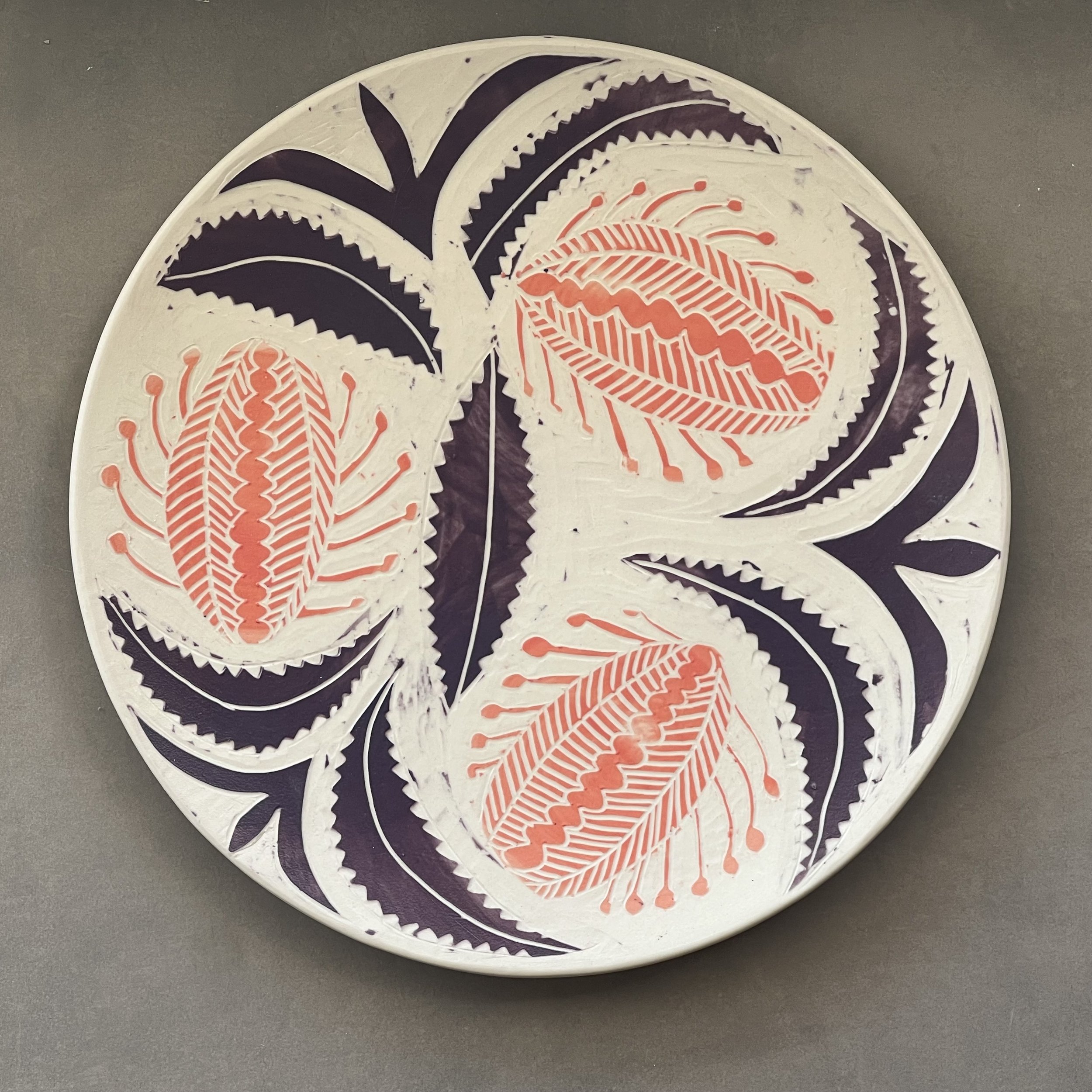 Dimity Kidston sgraffito hand carved ceramic plate with intricate orange and purple leaf and floral patterns.
