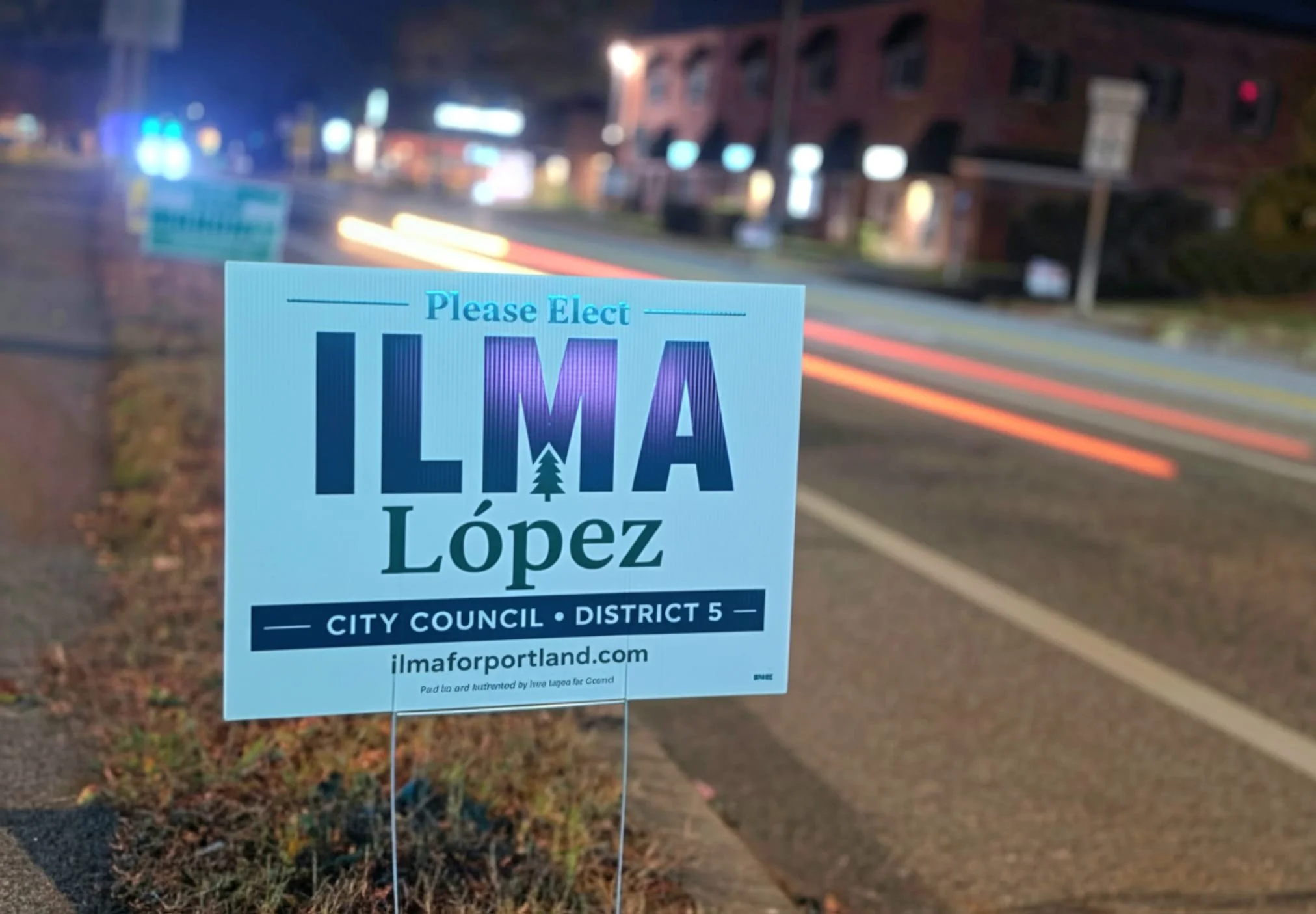 A political campaign sign on a lawn promoting Ilma López for City Council, District 5, in Portland, Maine, at night. Yard sign for Ilma Lopez for Portland Maine city council district 5