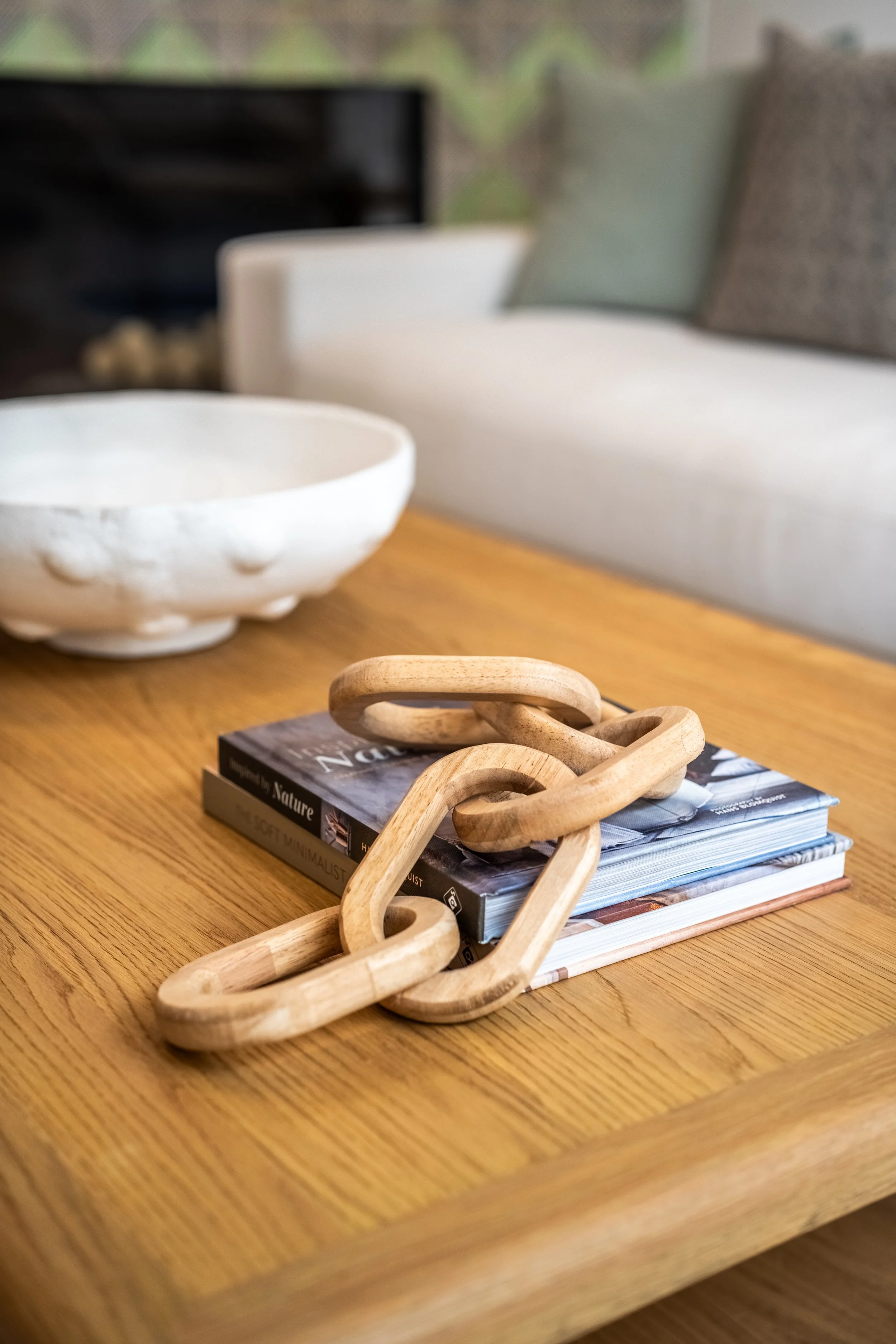 Styled wood coffee table at The Solana House with sculptural decor, books and ceramic bowl in Solana Beach, California