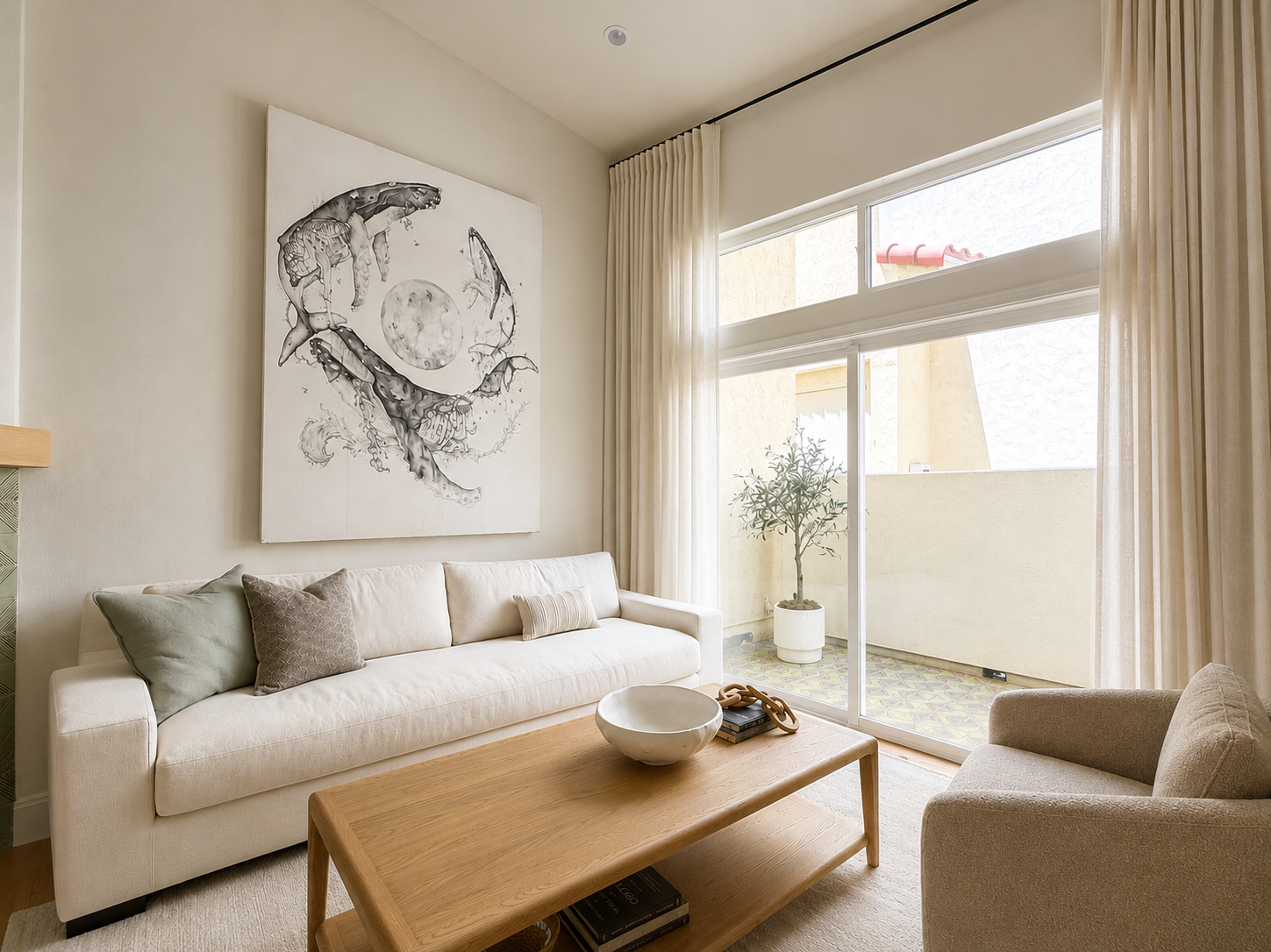Bright coastal living room at The Solana House in Solana Beach with neutral furnishings, ocean-inspired artwork and floor-to-ceiling linen curtains
