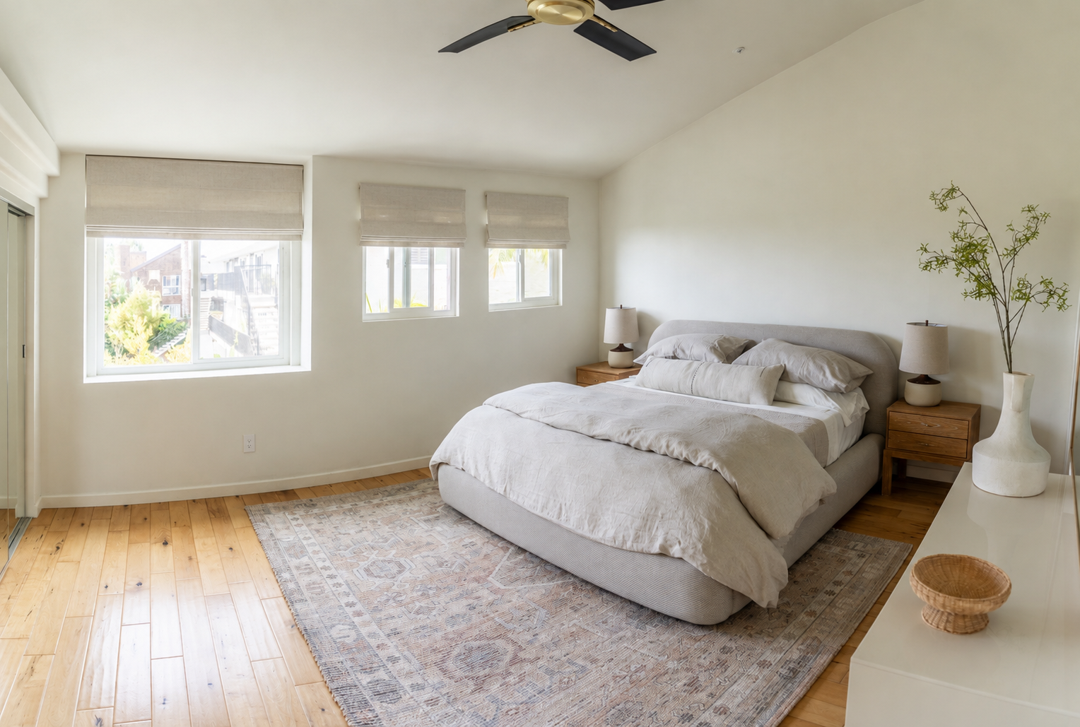 Serene primary bedroom at The Solana House with king bed, luxury neutral linens, warm wood floors, and natural light.