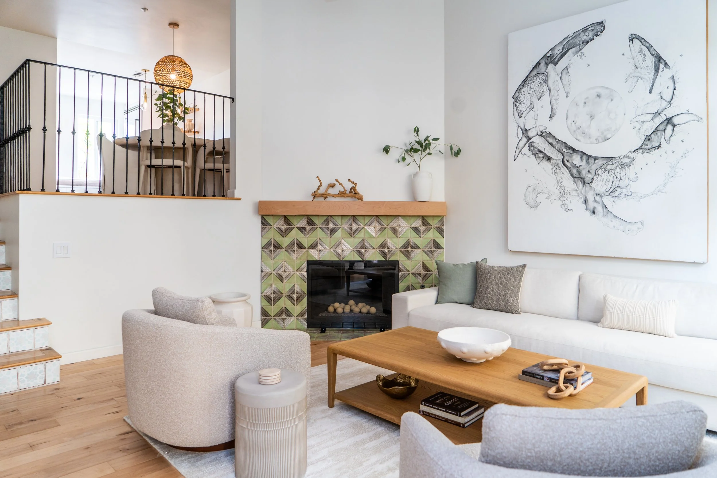 Bright coastal living room at The Solana House with fireplace, neutral furnishings and natural wood accents in Solana Beach, California
