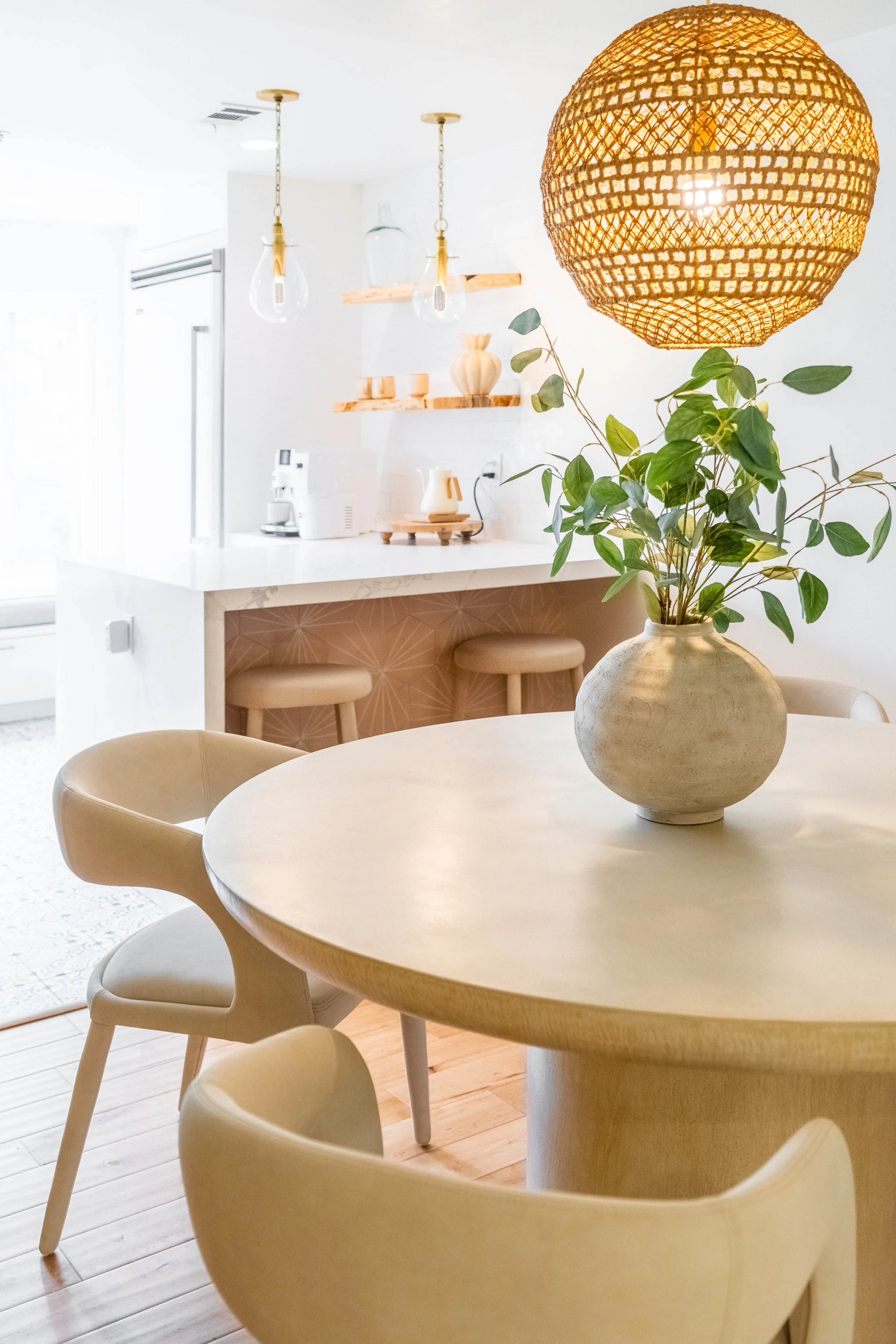Woven pendant lighting and natural greenery add warm coastal style to The Solana House kitchen.