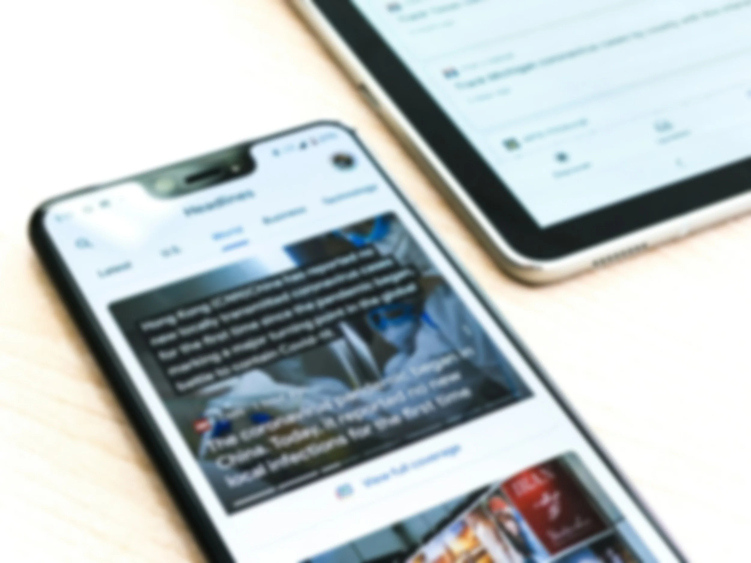 Two smartphones on a table, displaying social media feeds with images and text.