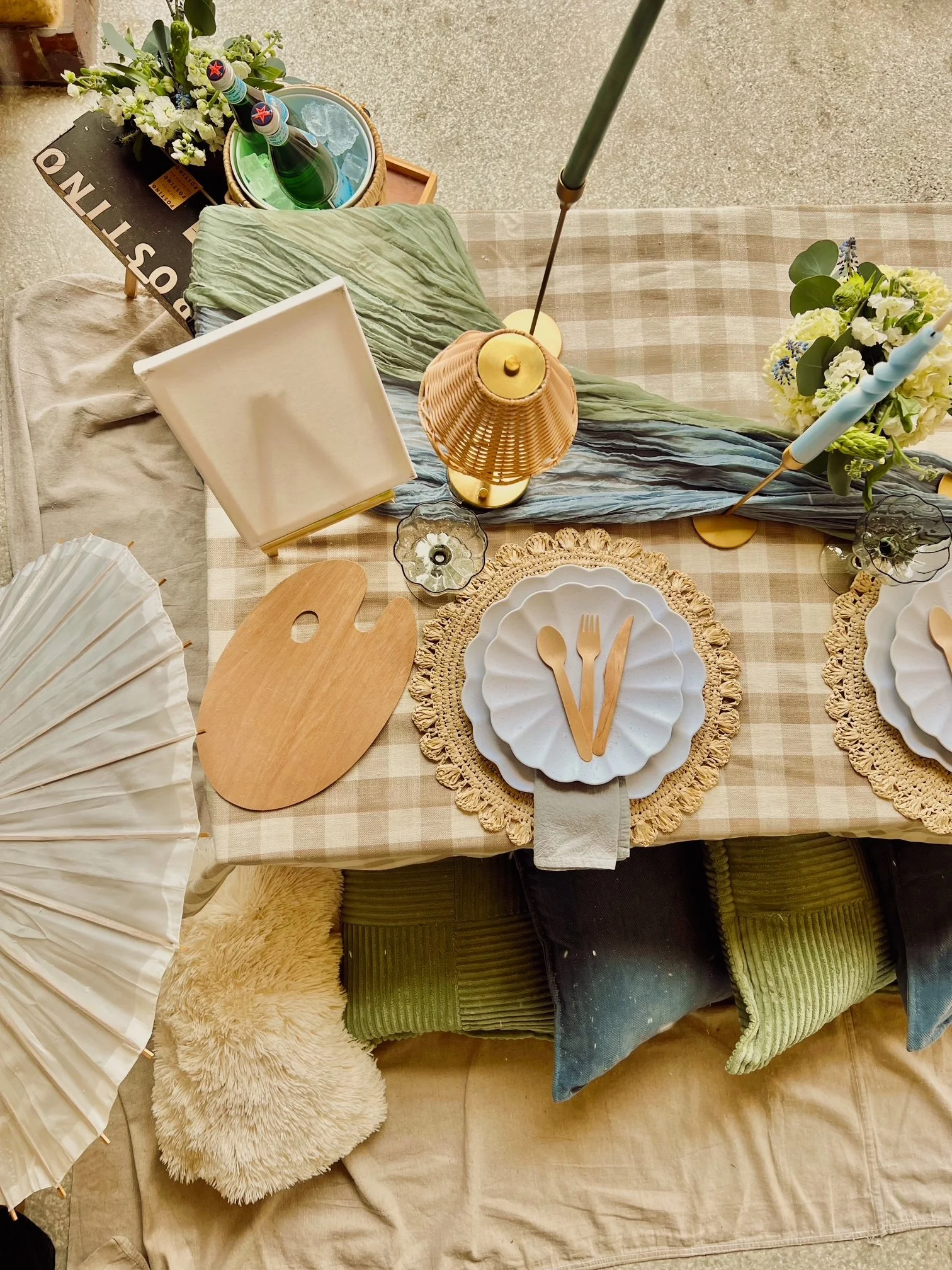 A decorated table set for a meal with plates, cutlery, and flowers, surrounded by chairs with cushions and plush rugs underneath.