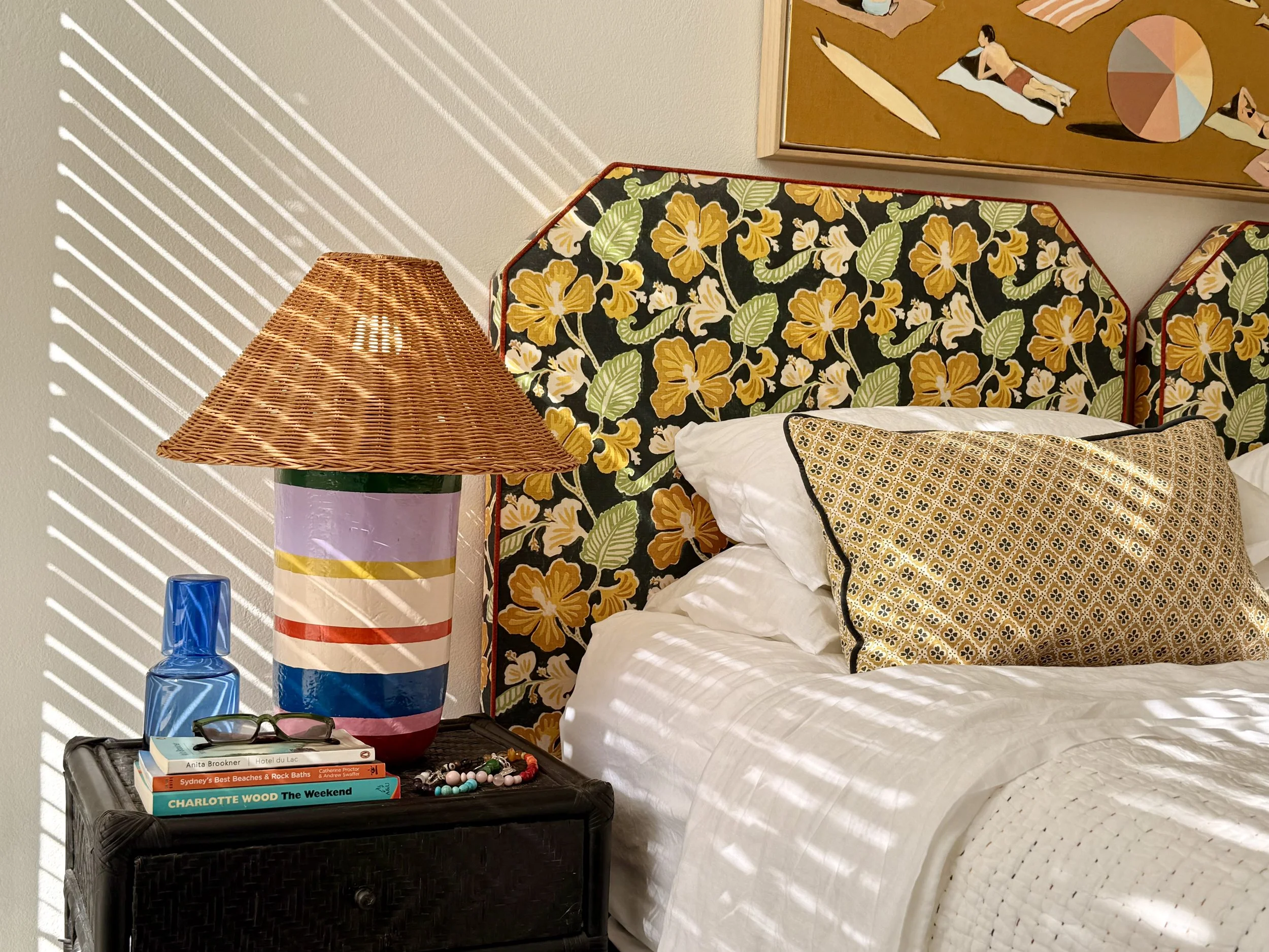 Detail of the Pool Room with custom Anna Spiro floral Oahu fabric bedheads, white CULTIVER linen, Anna Spiro cushions and a striped Anna Spiro and Kit Kemp bedside lamp.