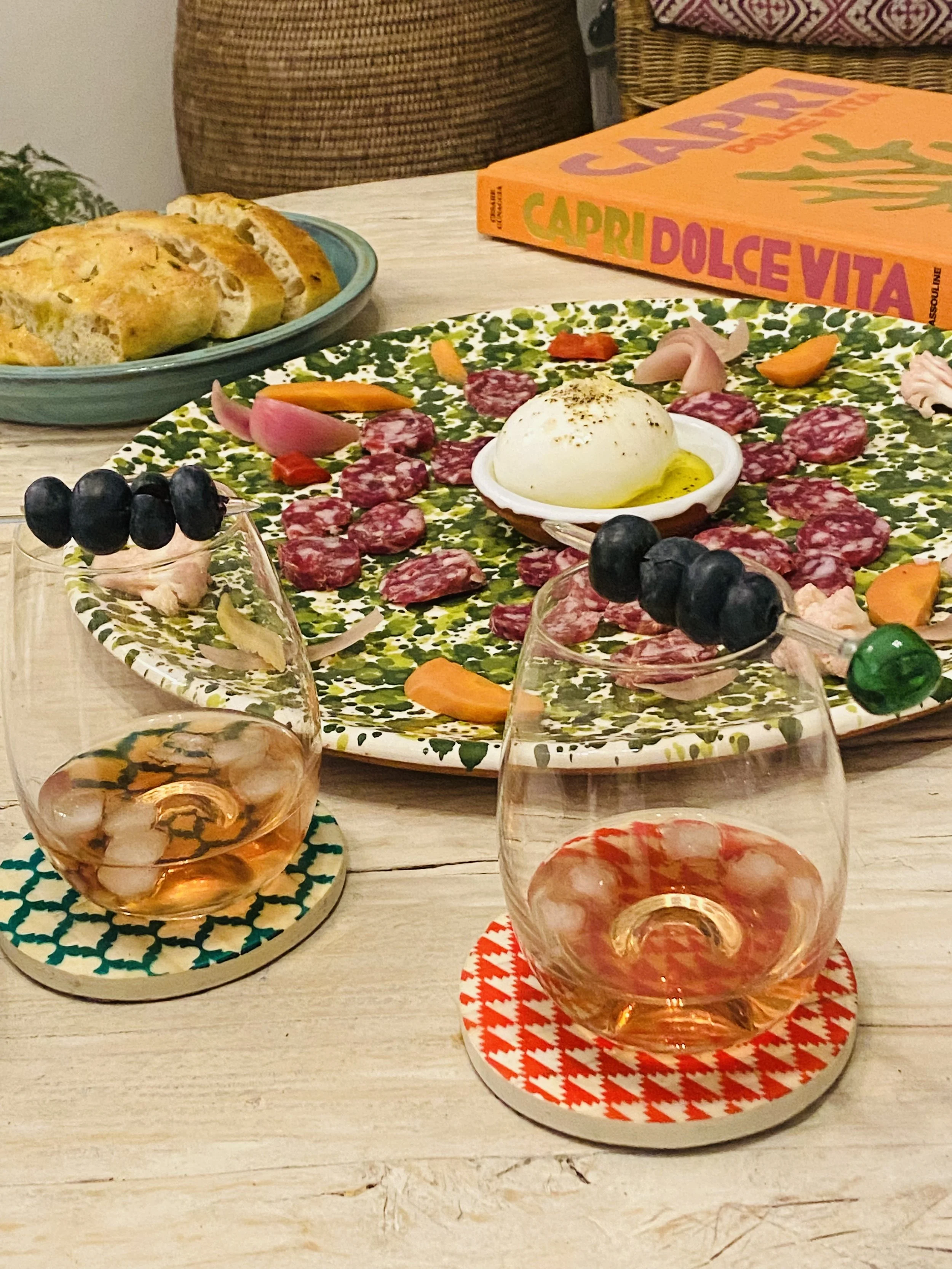 Aperitivo spread at Sea Fan with wine, burrata, charcuterie and bread, served on colourful tableware in the living area