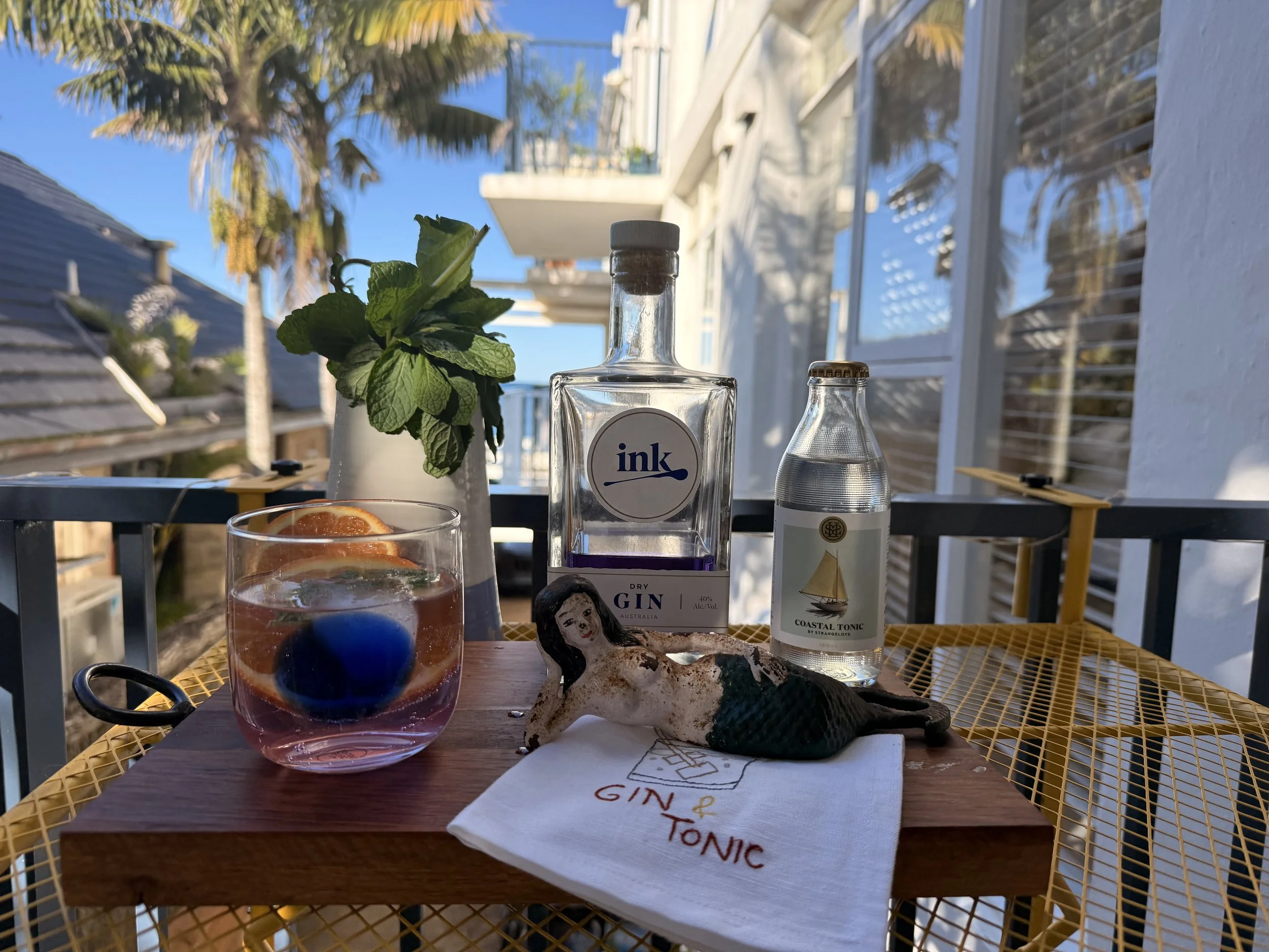 Sea Fan Sunset welcome drink with Ink Gin and tonic, set on the balcony overlooking the tropical garden.