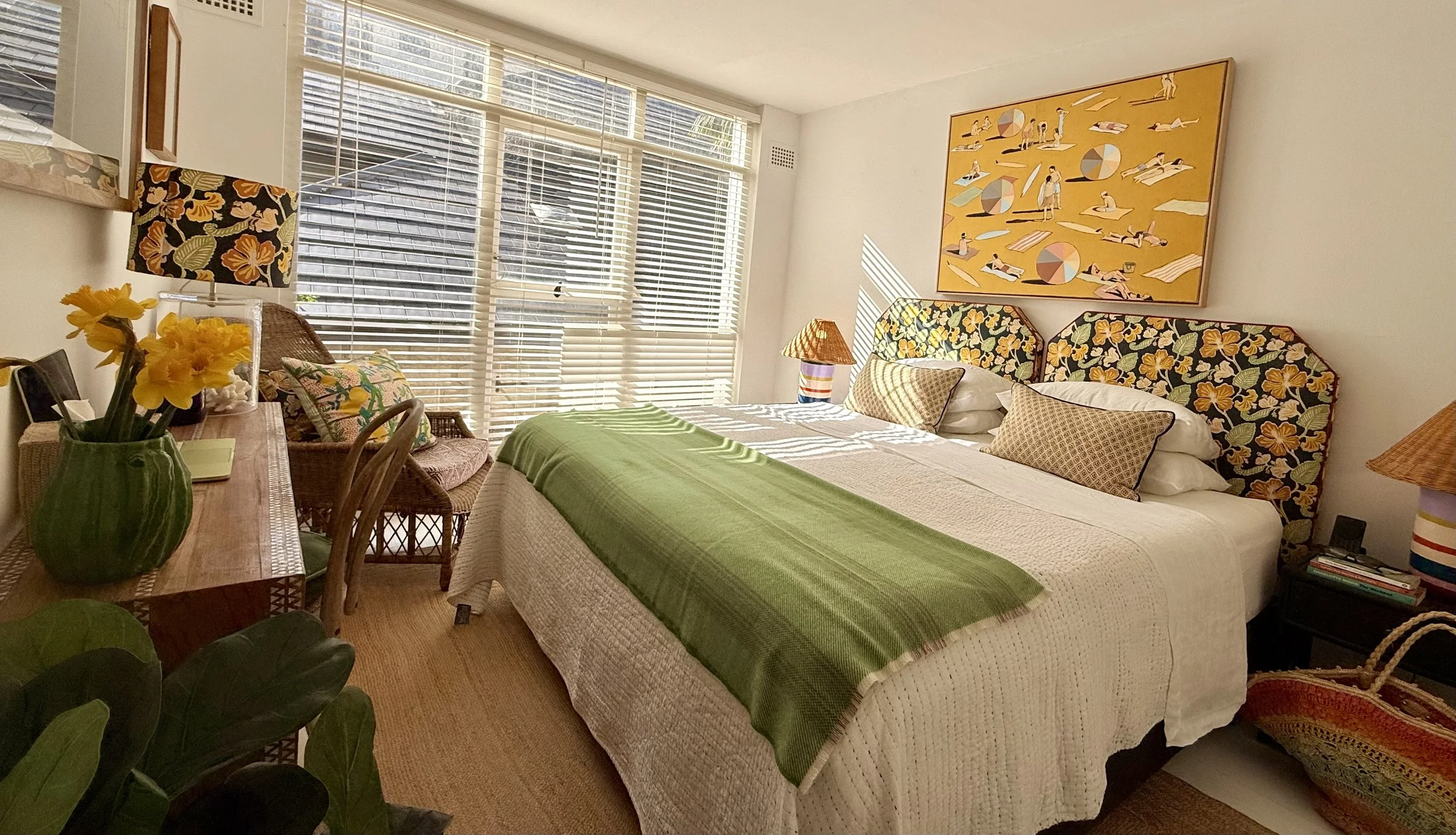 The Pool Room, Sea Fan’s main bedroom, configured as a king with custom Anna Spiro floral fabric bedheads, white linen and a green wool blanket.