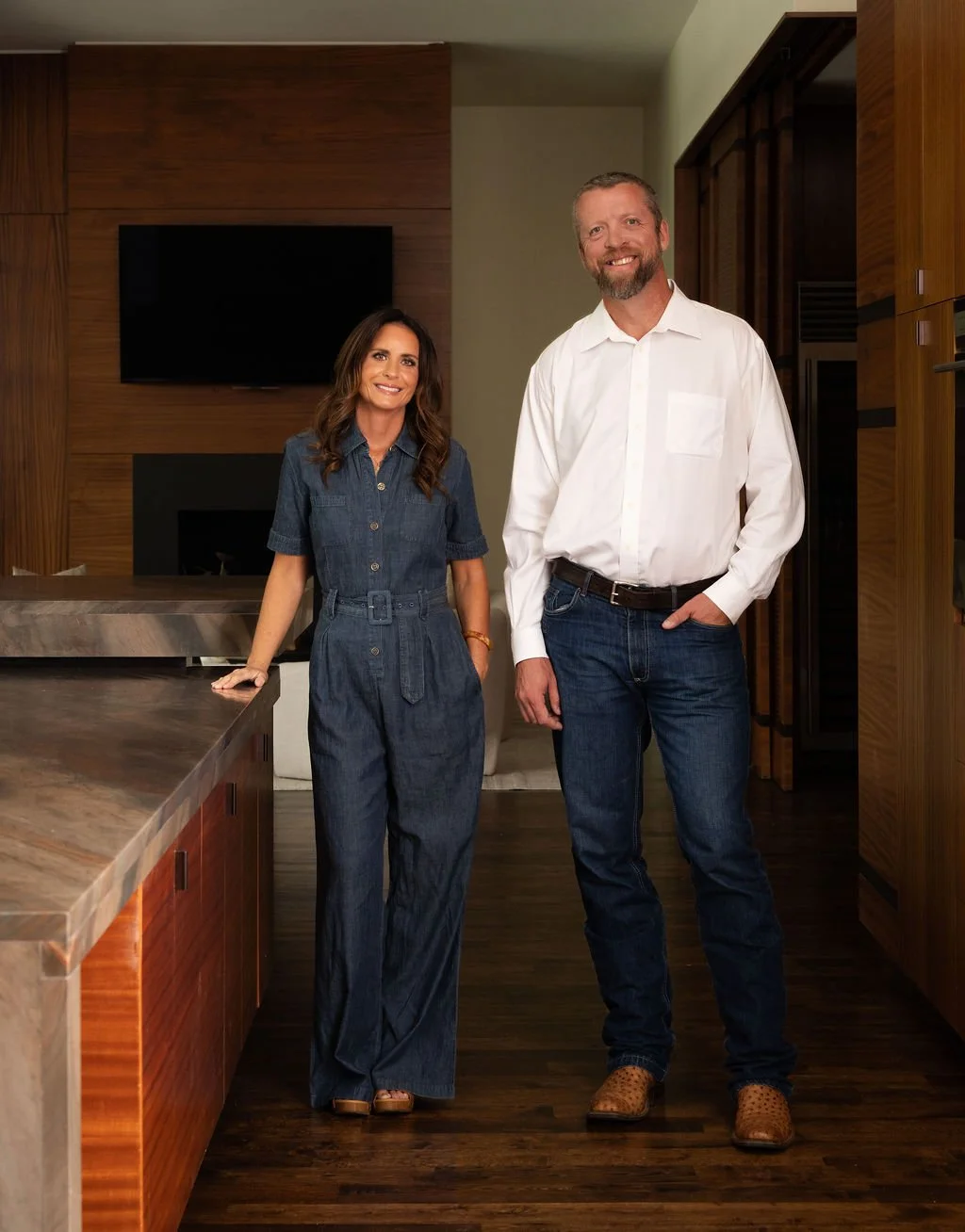 Brittany Sircy and Josh Walker, of Sircy & Co. stands in a modern kitchen, smiling and posing for the camera.
