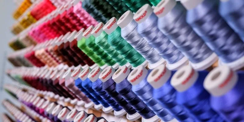 Rayons de fil à coudre colorés en ordre dans un magasin.