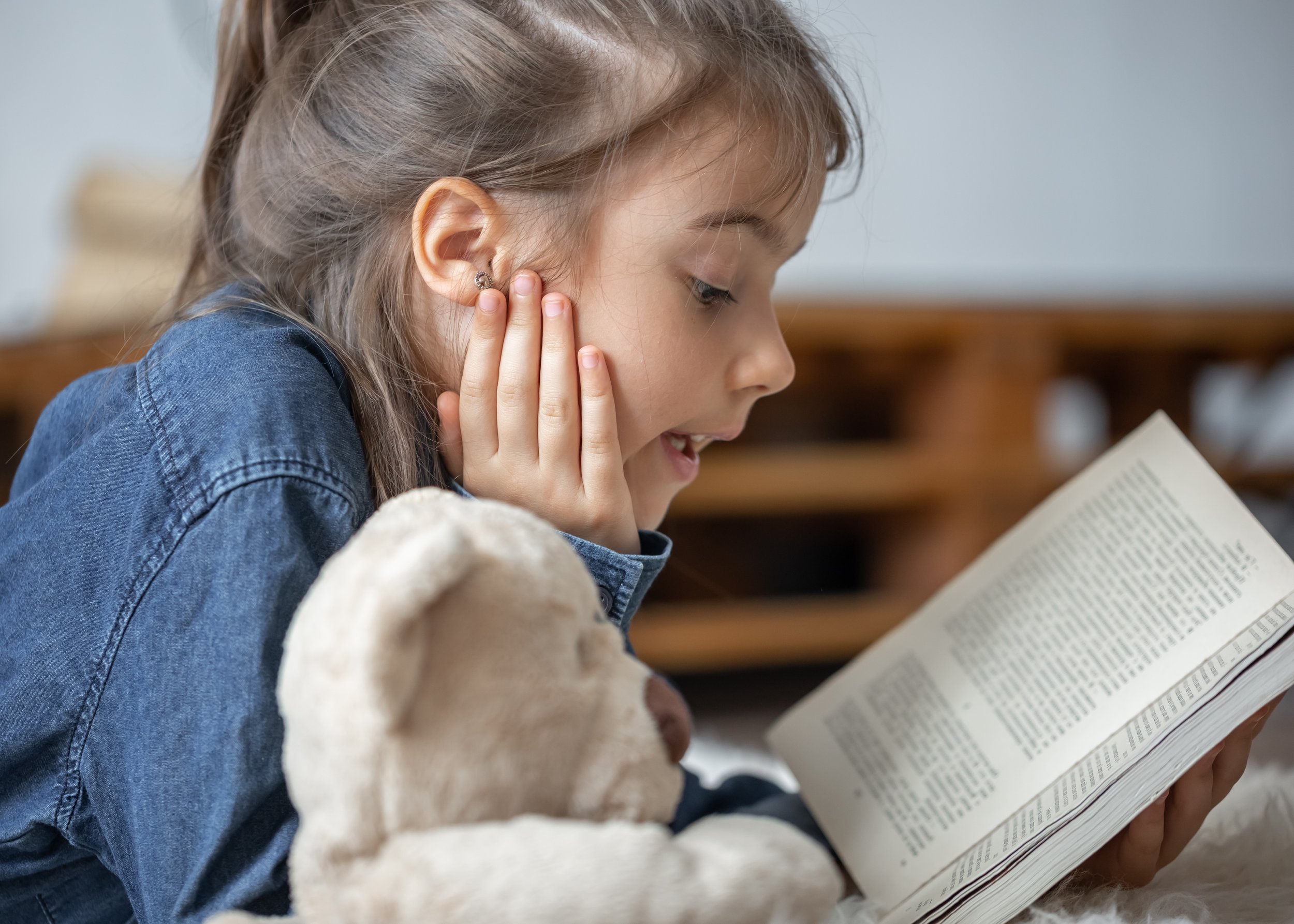 pretty-little-girl-home-lying-floor-with-her-favorite-toy-reads-book.jpg