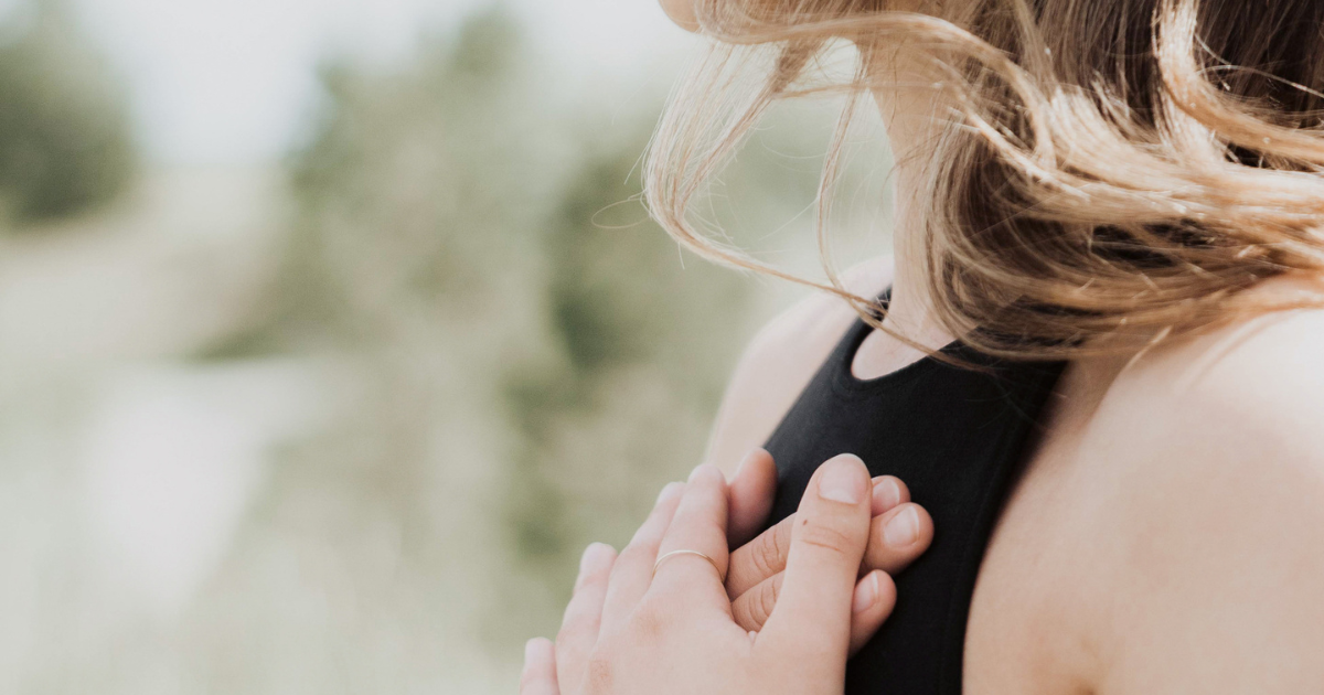 Woman holding her hand to her heart with eyes closed – symbolizing emotional release, peace, and the Forgiveness Virtue of The Soul Award