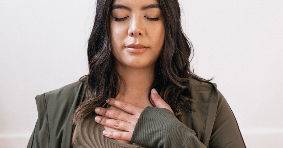 Woman with eyes closed and hand over heart, reflecting calm strength and emotional endurance – representing the Resilience Virtue of The Soul Award