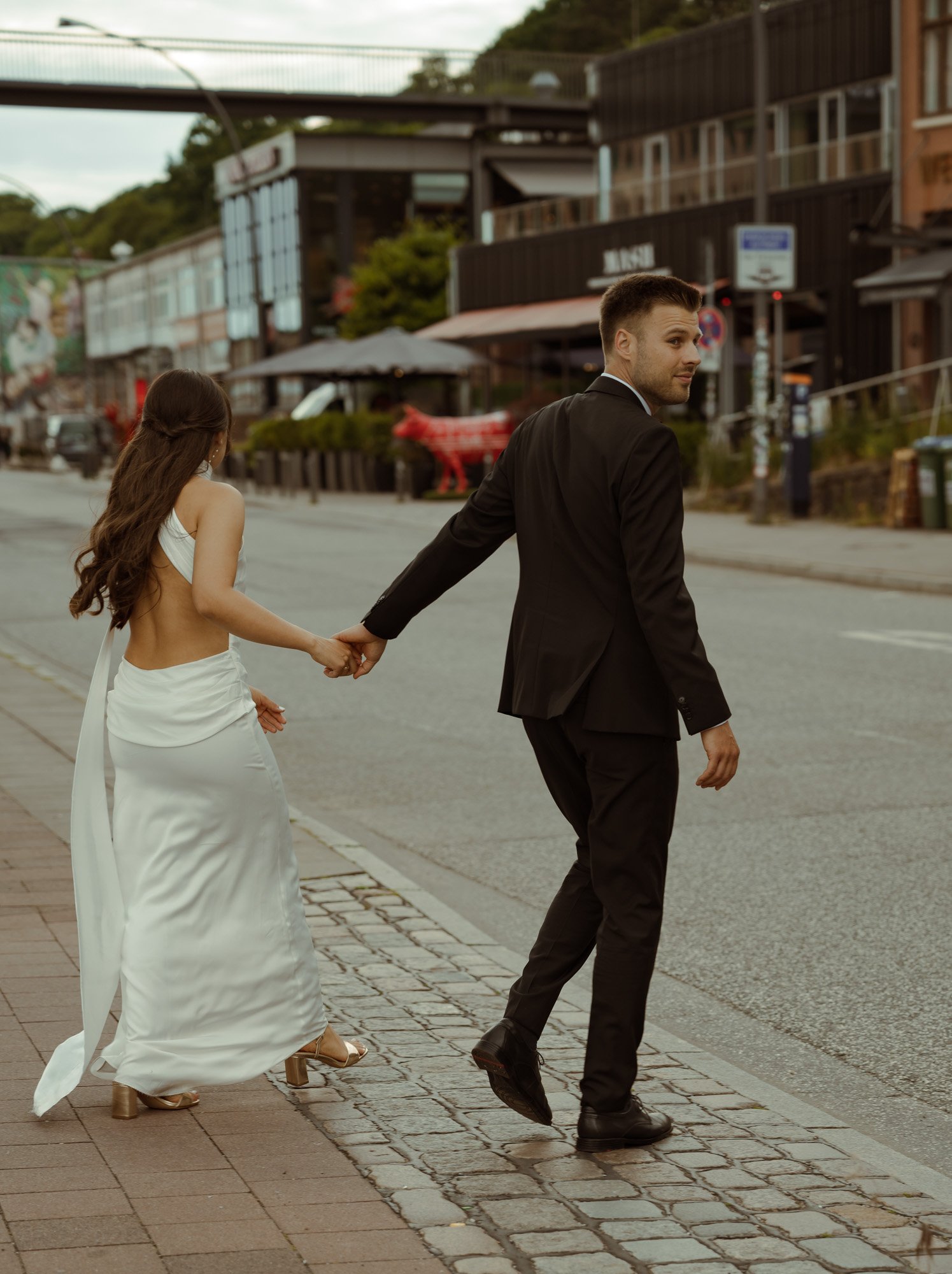 Brautpaar läuft Hand in Hand durch die Stadt.